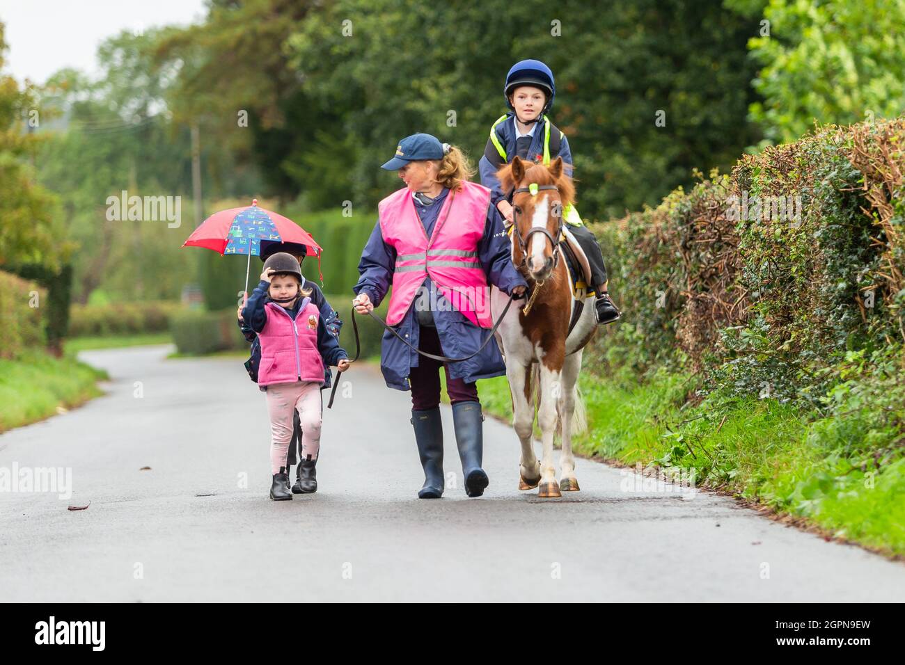 Upper Arley, Worcestershire, Regno Unito. 30 settembre 2021. La nonna Jane Mundie batte la crisi di carenza di carburante utilizzando il suo pony 'Fern' sulla corsa scolastica. I suoi nipoti Reggie, 5, Myla, 2, e Henley, 8, si gira per cavalcare il pony le due miglia per Upper Arley C della scuola elementare e nel Worcestershire rurale. "Al momento non riesco a ottenere il diesel per la mia Land Rover, ma non dobbiamo preoccuparci troppo quando i bambini hanno il nostro pony, Fern. Ed è sicuramente un modo divertente e verde per andare a scuola", afferma Jane. Credit: Peter Lopeman/Alamy Live News Foto Stock