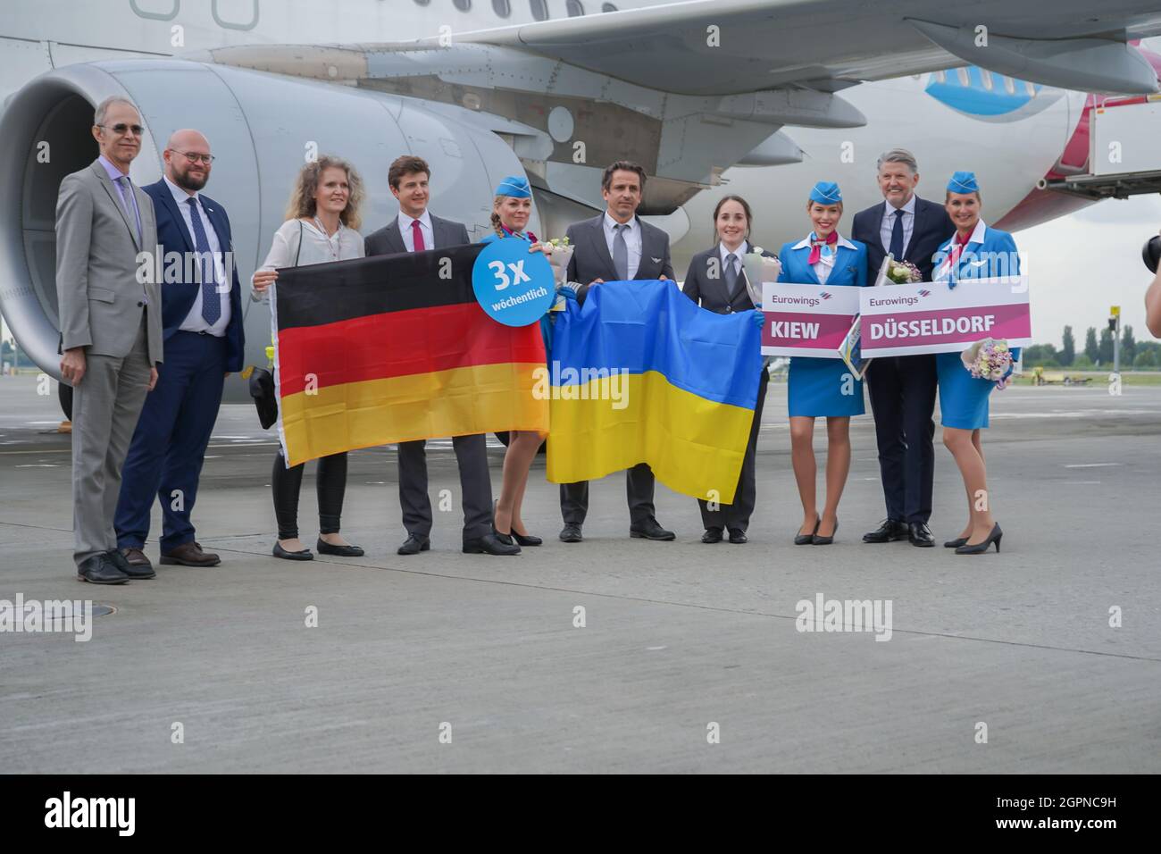 Ucraina, Kiev - 1 settembre 2021: Stewardesses e piloti. Stewardess che detiene la bandiera della Germania. Il pilota sorride. Equipaggio. Aereo della compagnia aerea Eurowings. Aircraft Airbus A320-214 D-AEWU all'aeroporto. Foto Stock