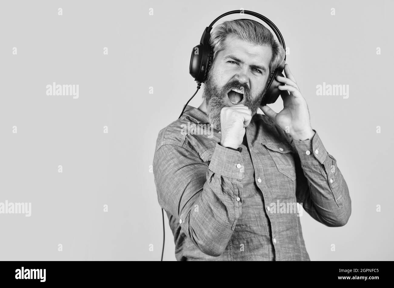 Ascoltare la sua musica preferita. Uomo che ascolta la musica con le cuffie. Uomo che ha barbato hipster in cuffia. Ascolto di musica. È il momento di rilassarsi. Brutale Foto Stock