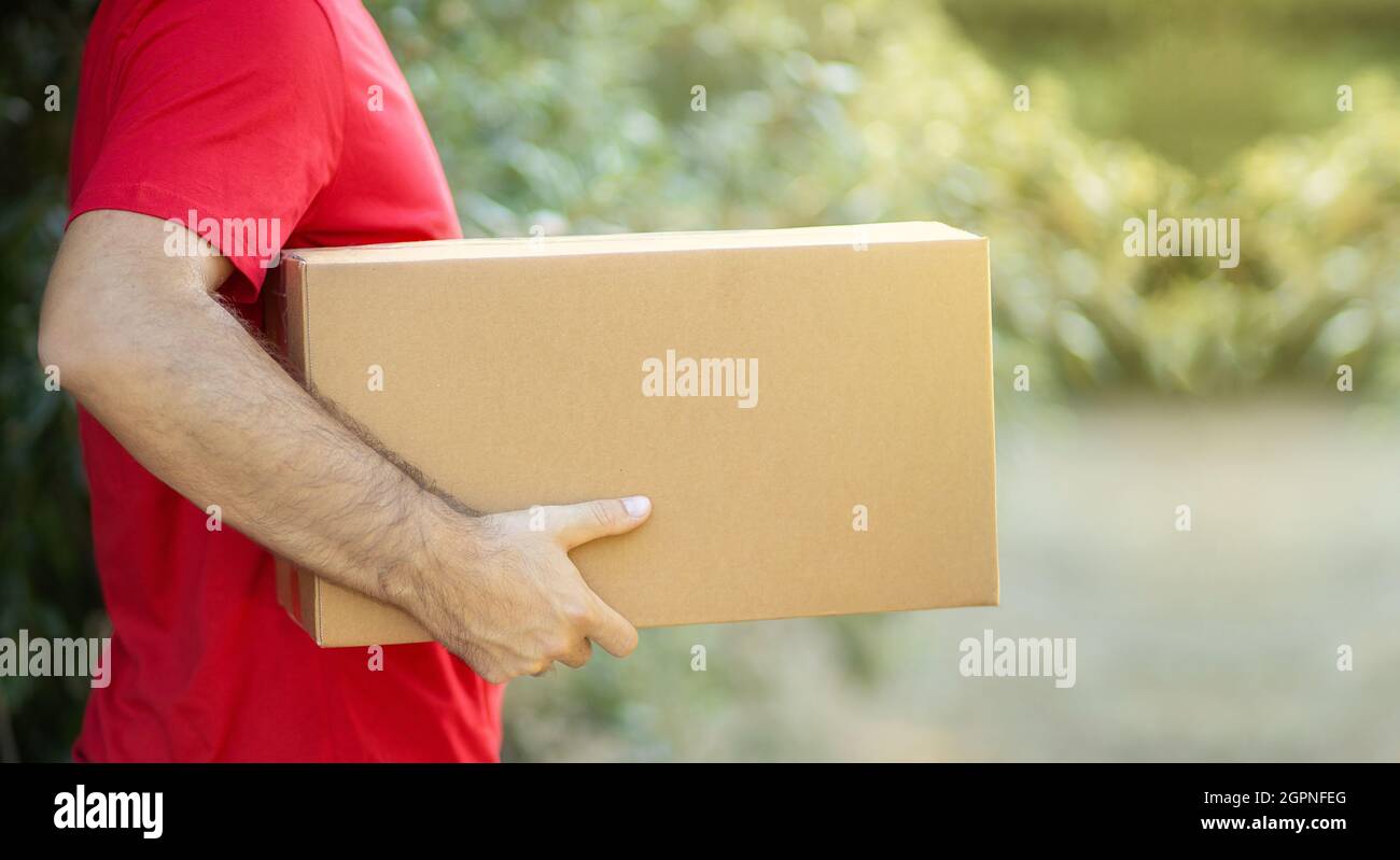 Addetto alla consegna che tiene scatole di cartone in azienda. Shopping online e consegna espressa Courier ordinare a casa online concetto di shopping biologico Foto Stock