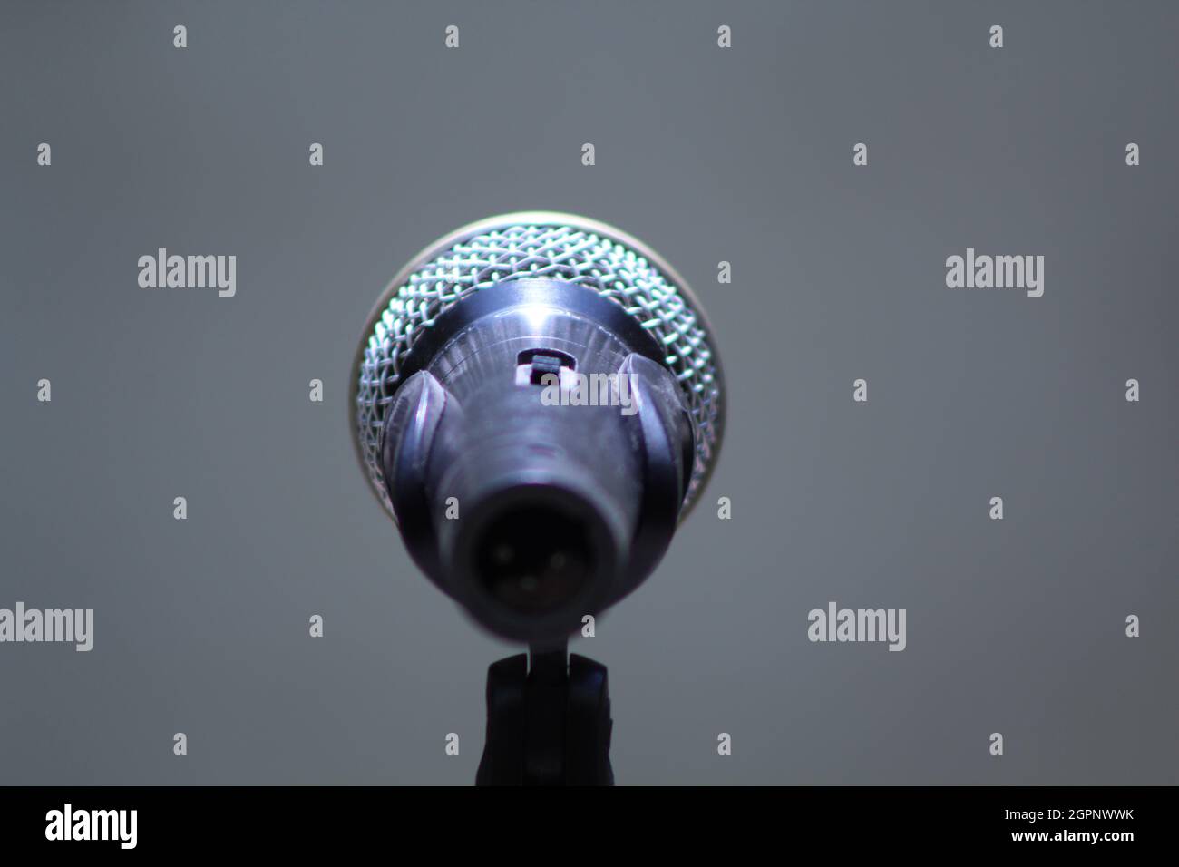 Primo piano di microfono vocale dinamico dal retro vista apparecchiature audio cantare spettacolo sala concerti microfono Foto Stock