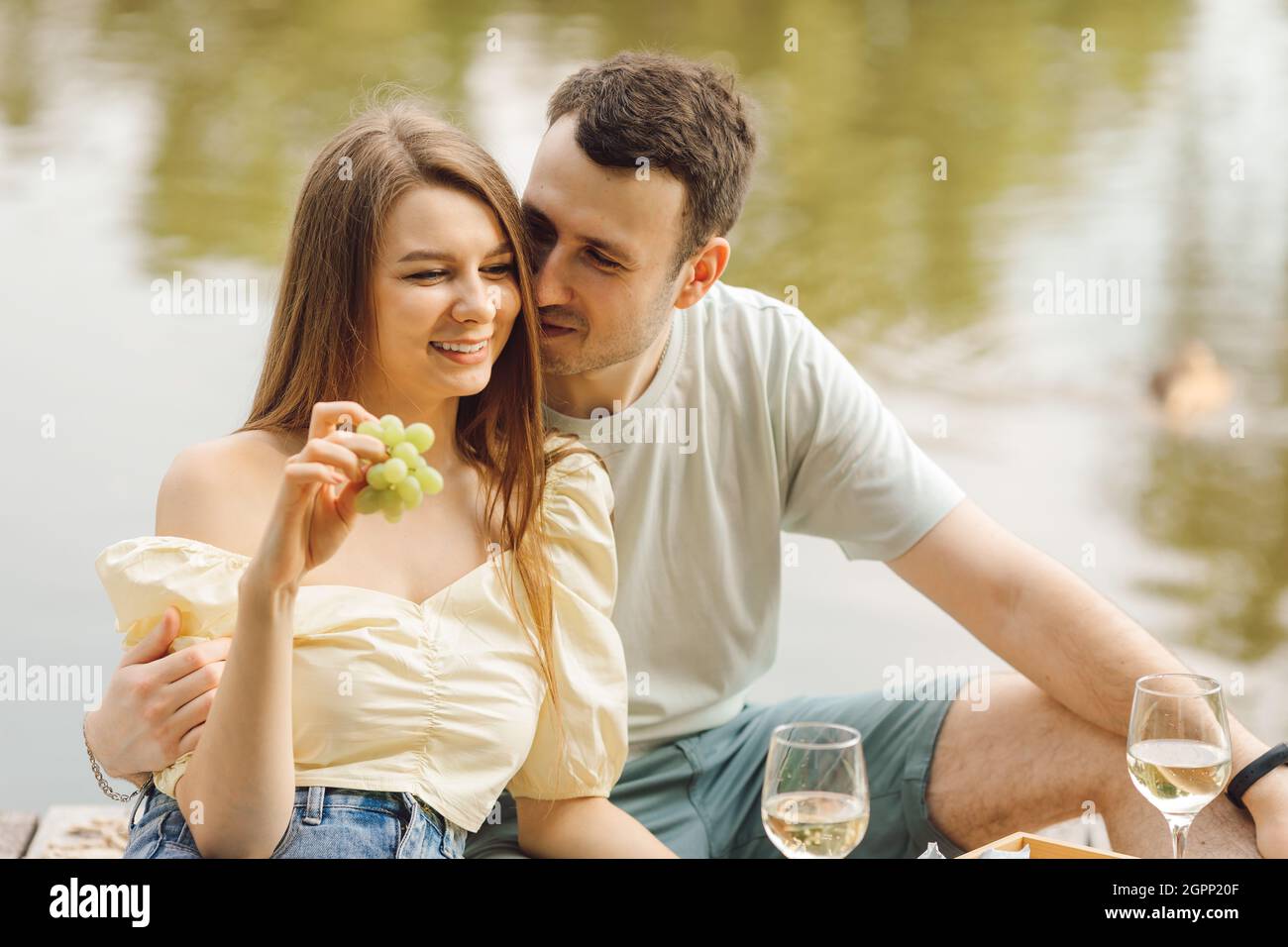 Coppia in un romantico pic-nic il giorno d'estate con champagne e uva. Dolce vita. Felicità e serenità. Momenti meravigliosi della vita. Super giorno. Romantico Foto Stock