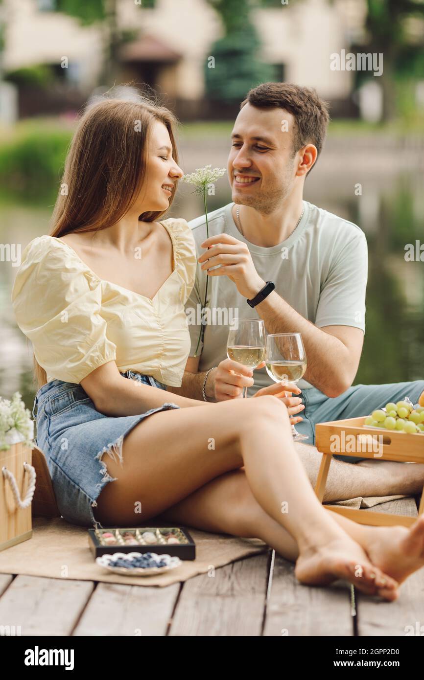 Relazioni romantiche al pic-nic il giorno d'estate su terrazza riscaldata in legno. Dolce vita. Felicità e serenità. Riposo e divertimento. Momenti meravigliosi della vita Foto Stock