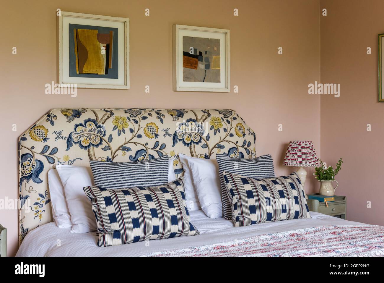 Testiera vintage con cuscini a righe e ikat, Hampshire, Regno Unito Foto Stock