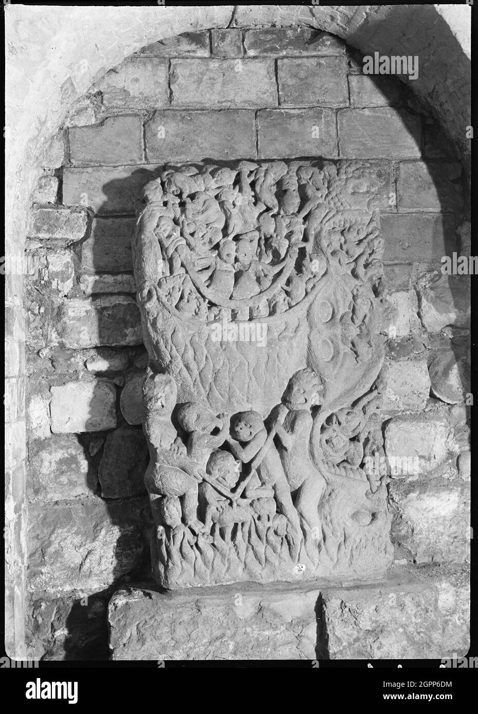 York Minster, Minster Yard, York, 1942. Una vista dettagliata di una pietra intagliata nella cripta della Cattedrale di York, conosciuta anche come Chiesa della Cattedrale di San Pietro. La pietra è posta all'interno di un muro e ha un intaglio di 'inferno'. Le figure demoniache sono in fiamme. Sopra è presente un'area circolare che sembra riempita di figure. Foto Stock