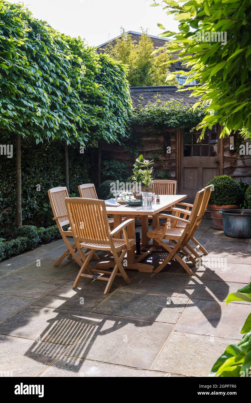 Tavolo e sedie nel cortile privato lastricato della casa South London Foto Stock