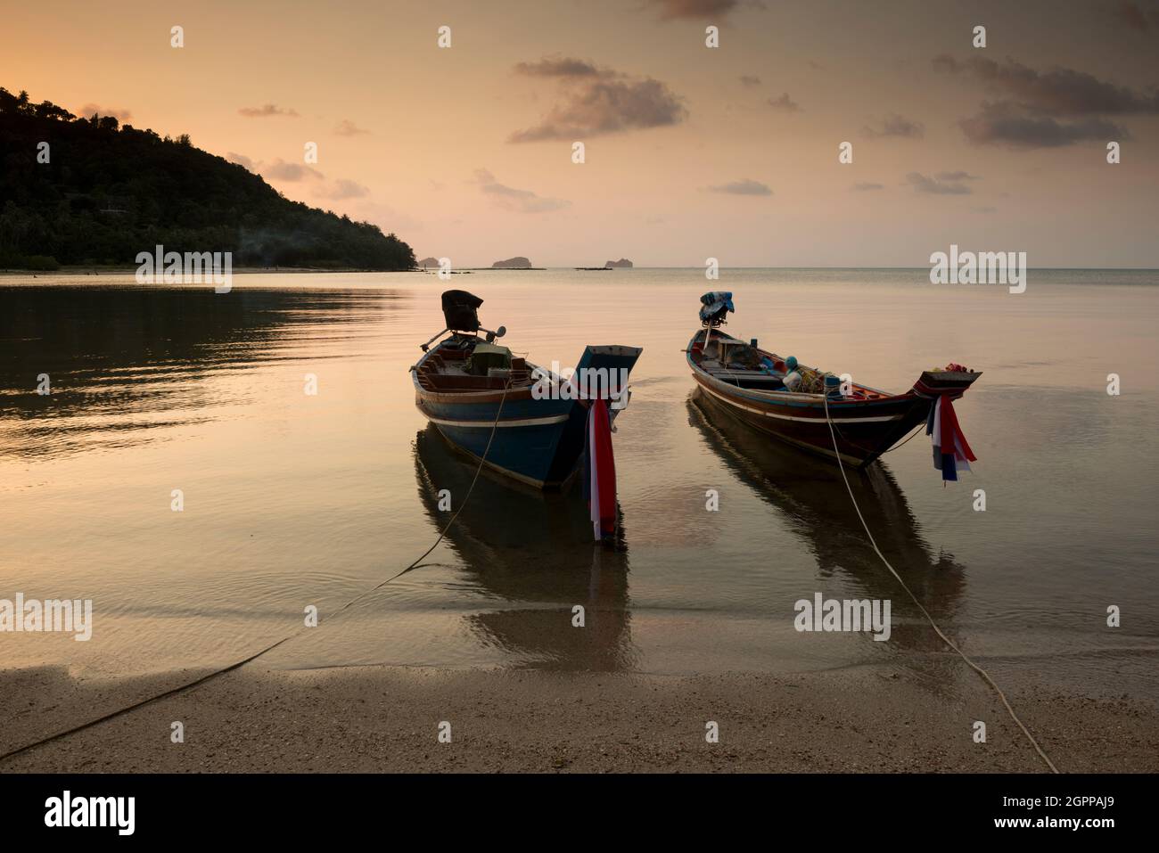 Thailandia, isola di Ko Samui, barche tradizionali ormeggiate sulla spiaggia al tramonto Foto Stock