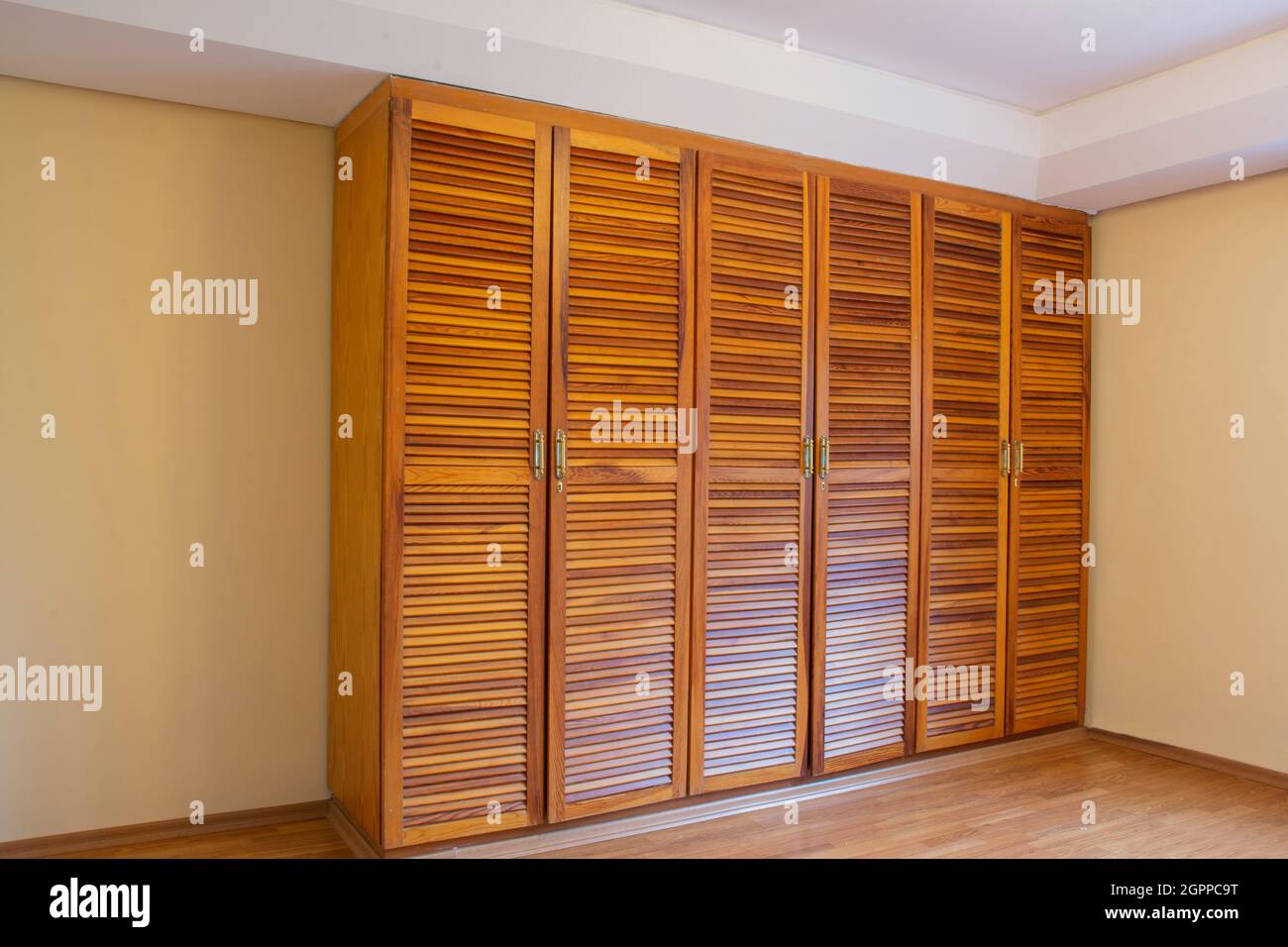 armadio in legno massello con sei porte in camera con pavimento in parquet  vuoto Foto stock - Alamy