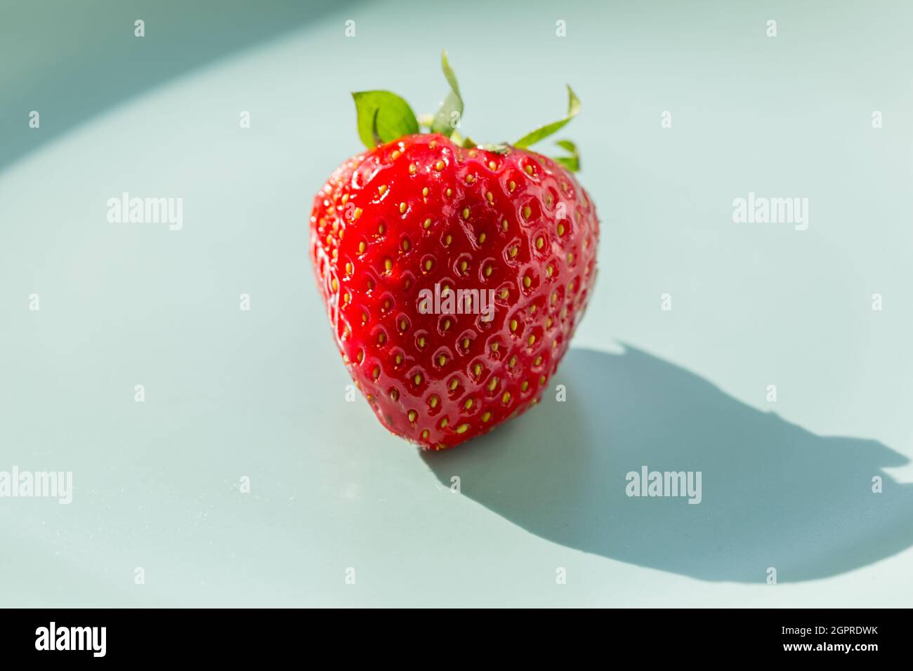 Una fragola rossa sul piatto verde. Concetto di stile di vita sano. Foto Stock