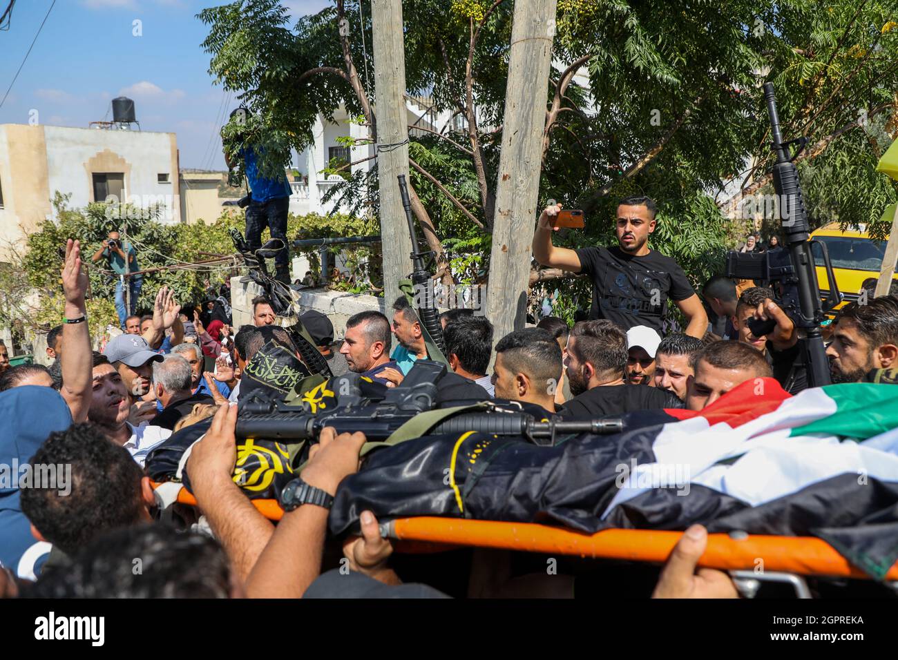 Jenin, Cisgiordania, Palestina. 30 settembre 2021. Jenin, Cisgiordania, Palestina. 30 settembre 2021. I lutto accompagnano il corpo di Alaa Nasser Mohammed Zayyoud, 22, in al-Sila al-Harithiya, a nord-ovest di Jenin, durante il suo funerale di Giovedi. Zayyoud, un presunto membro della Jihad islamica palestinese, è stato ucciso nelle prime ore di giovedì nel vicino villaggio di Burqin durante uno scontro armato con l'esercito israeliano a seguito di un raid notturno e di una ricerca di arresti. Due palestinesi sono stati feriti durante il raid notturno israeliano e portati in ospedale a Jenin. Non ci era segnalazione di lesioni sustaine Foto Stock