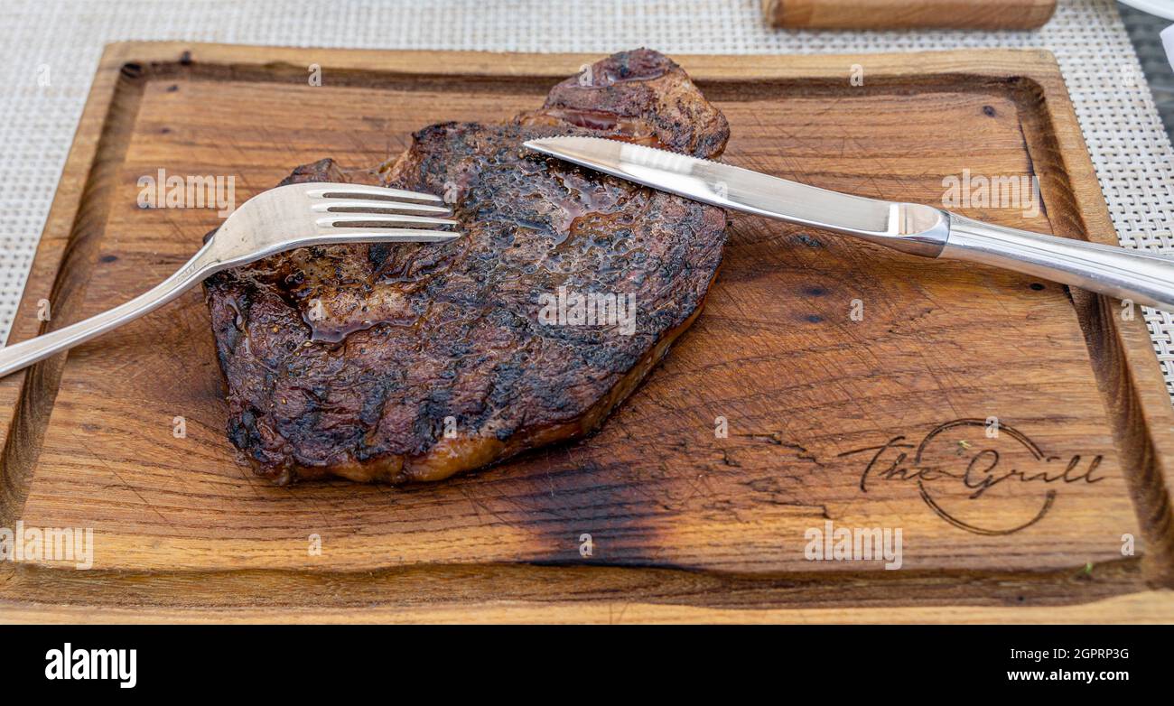 Bistecca costata servita su un piatto di legno, ristorante la Riviera al St Regis Nursultan, Kazakhstan Foto Stock