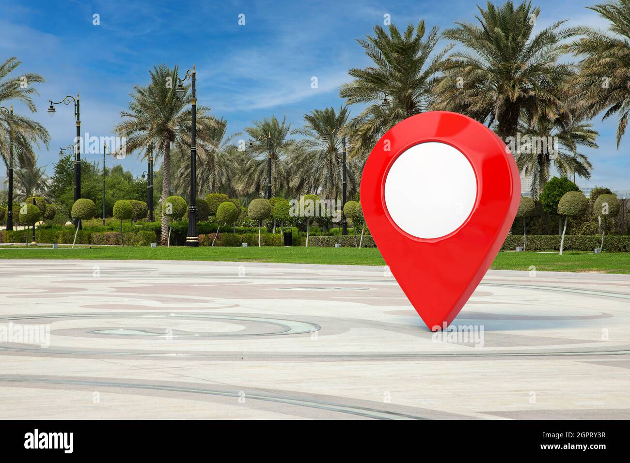 Puntino rosso sulla mappa in City Street vuota con palmeti da primo piano. Rendering 3d Foto Stock