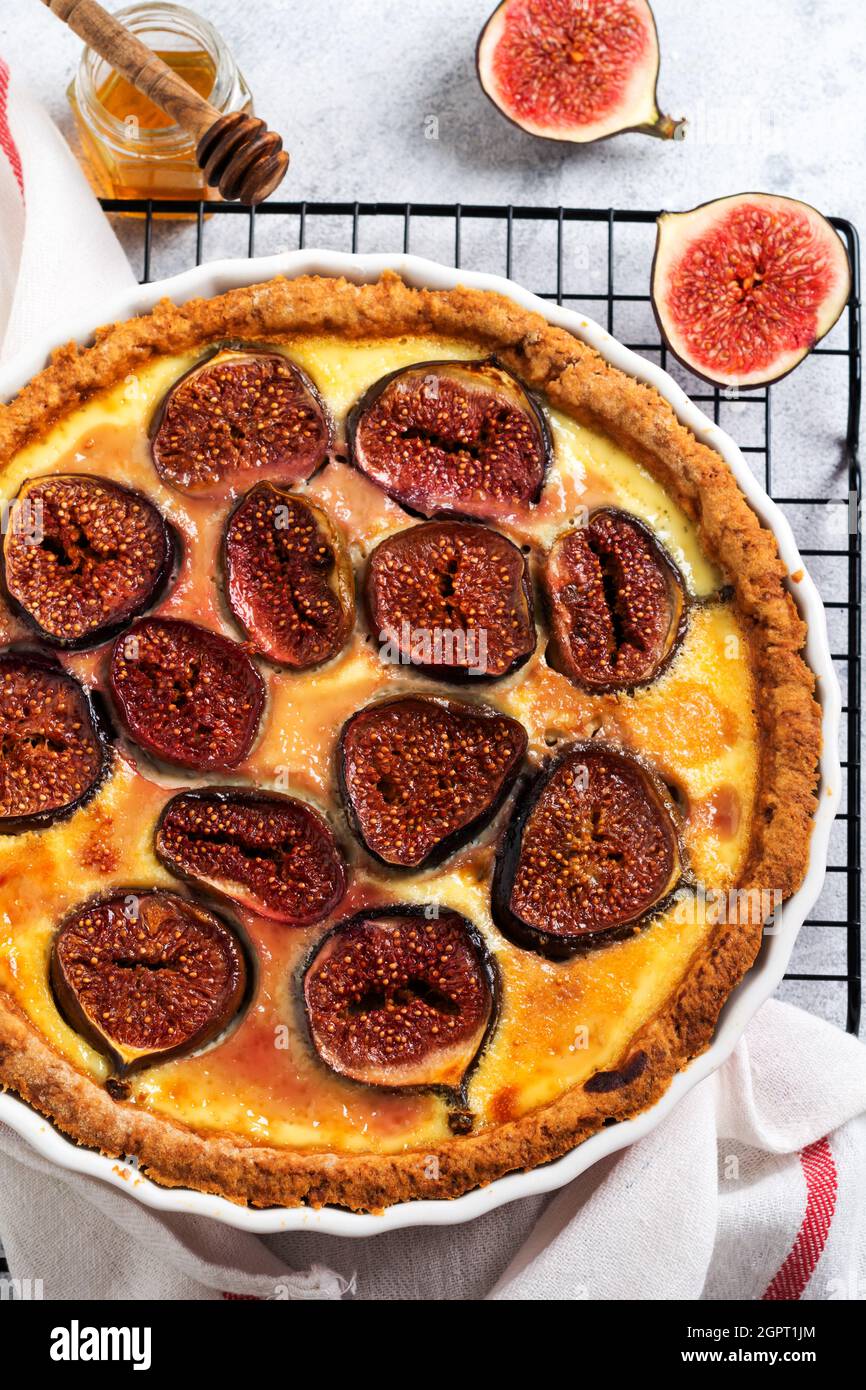 Fig. Tart. Deliziosa crostata con fichi freschi e formaggio di capra su un rustico tavolo in legno. Vista dall'alto Foto Stock