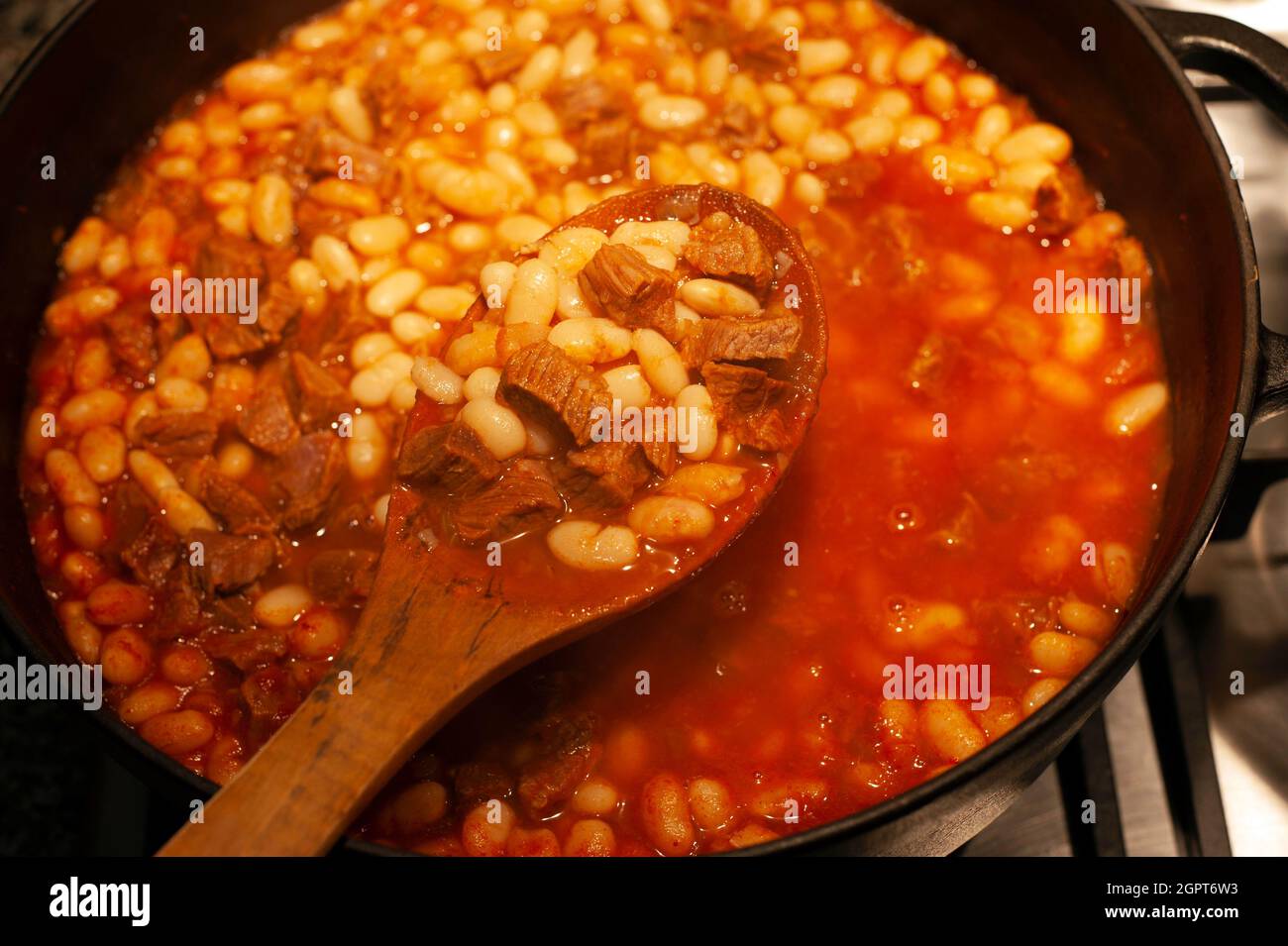 Farina di fagioli con carne in una pentola di ghisa Foto Stock
