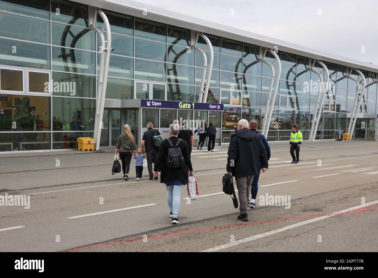 Passeggeri che camminano verso il terminal degli arrivi dell'aeroporto di Vagar, S¿rv‡gur, Sorvagur, Vagar Island, Faroe Islands, Europe. Foto Stock