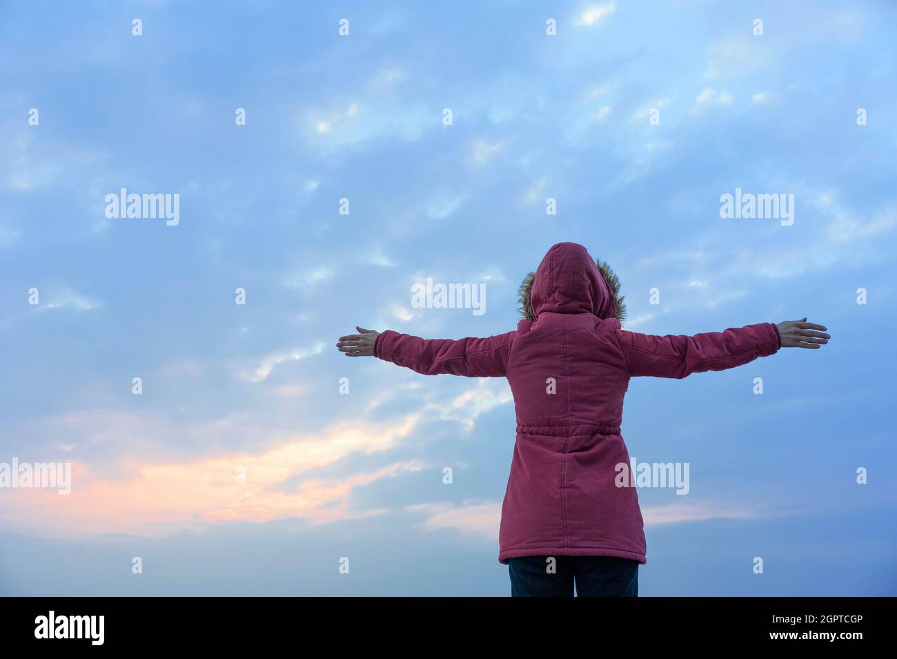 La signora con le braccia tese verso il mare Foto Stock