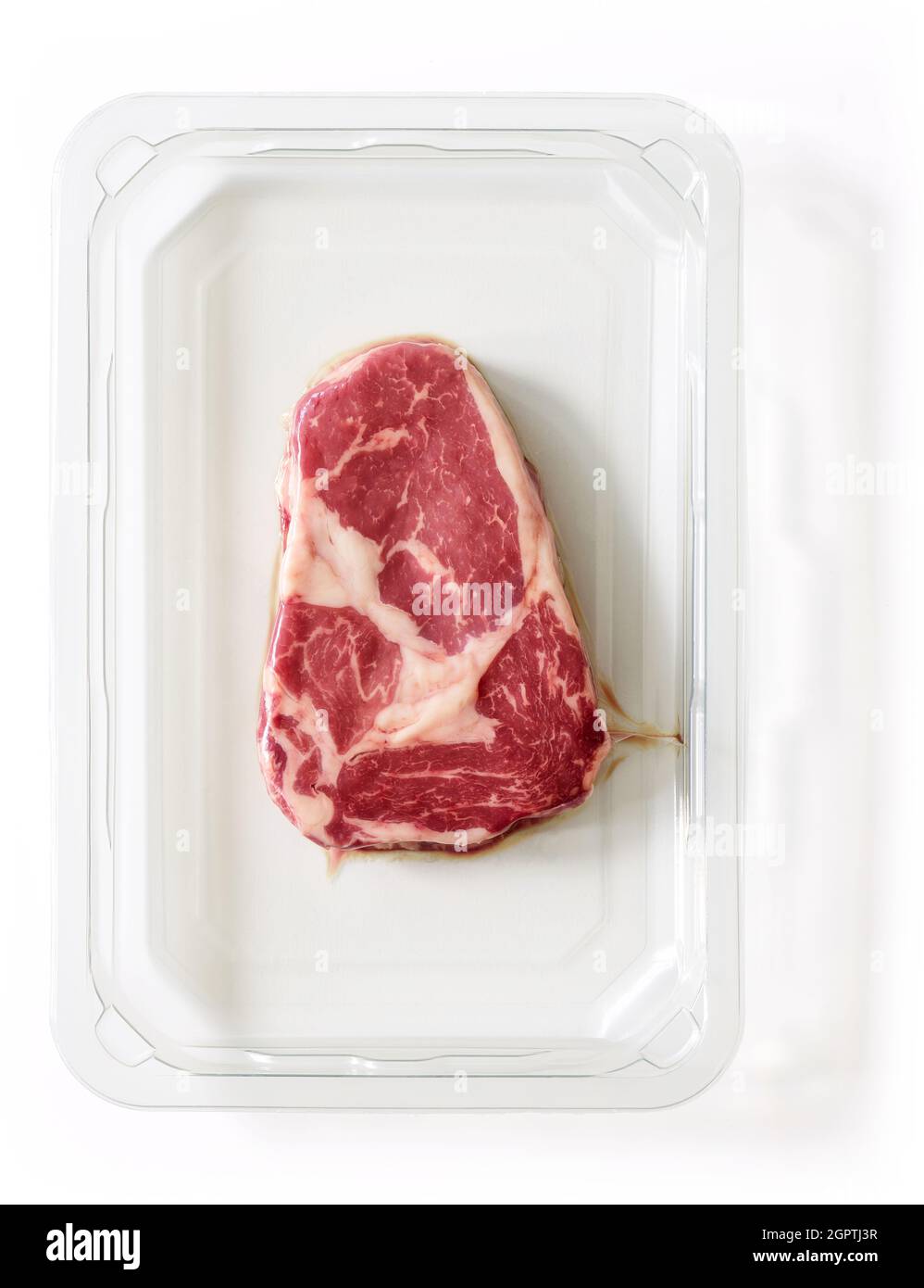 Bistecca cruda entrecote vacum confezionato isolato su sfondo bianco, vista dall'alto Foto Stock