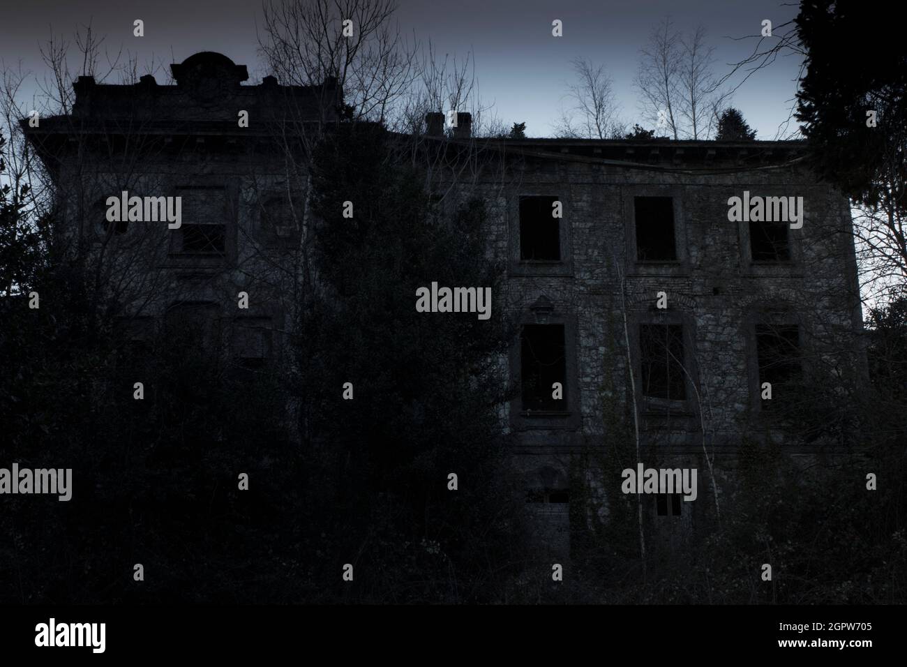 Casa abbandonata raffigurata al crepuscolo, con un aspetto spettrale adatto per cartoline per Halloween Foto Stock