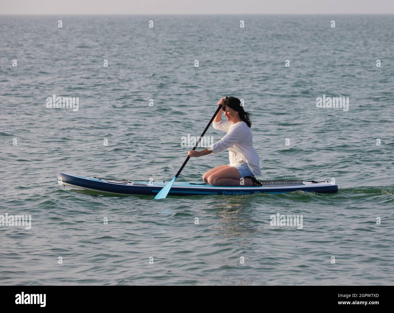 Donna ha visto paddle boarding al mare Regno Unito. Foto Stock