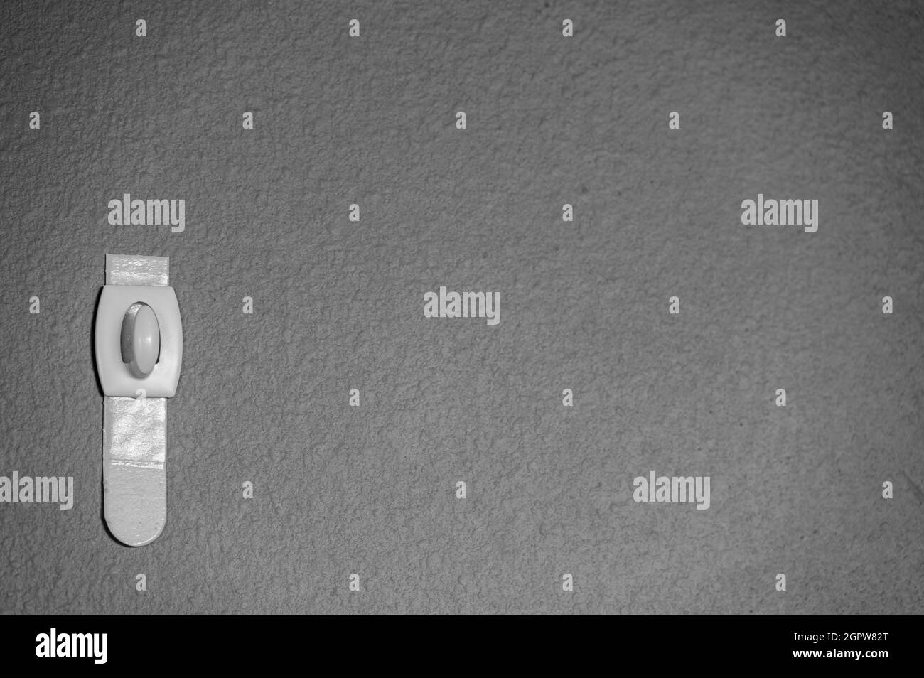 Messa a fuoco selettiva sulla staffa a parete della striscia adesiva che può essere rimossa tirando il nastro Foto Stock