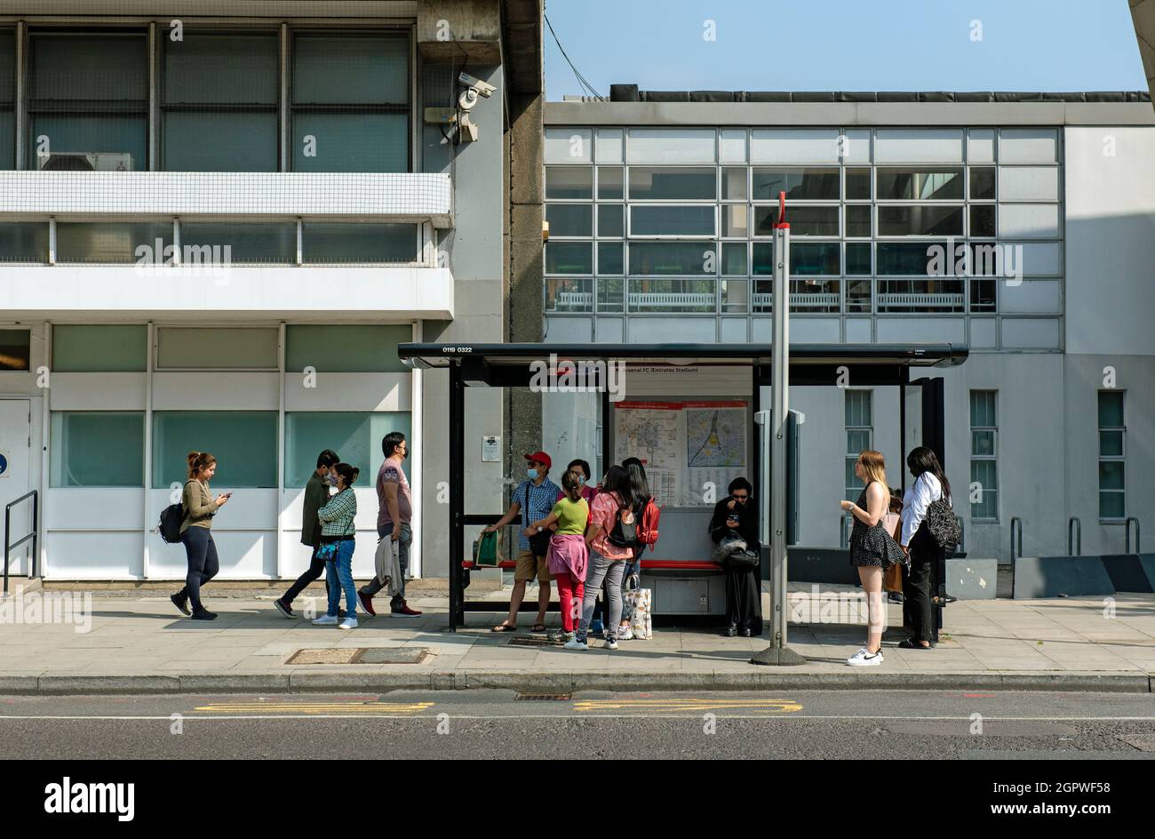 La gente che fila alla fermata dell'autobus, Holloway Road, London Brough of Islington, Inghilterra Gran Bretagna Foto Stock