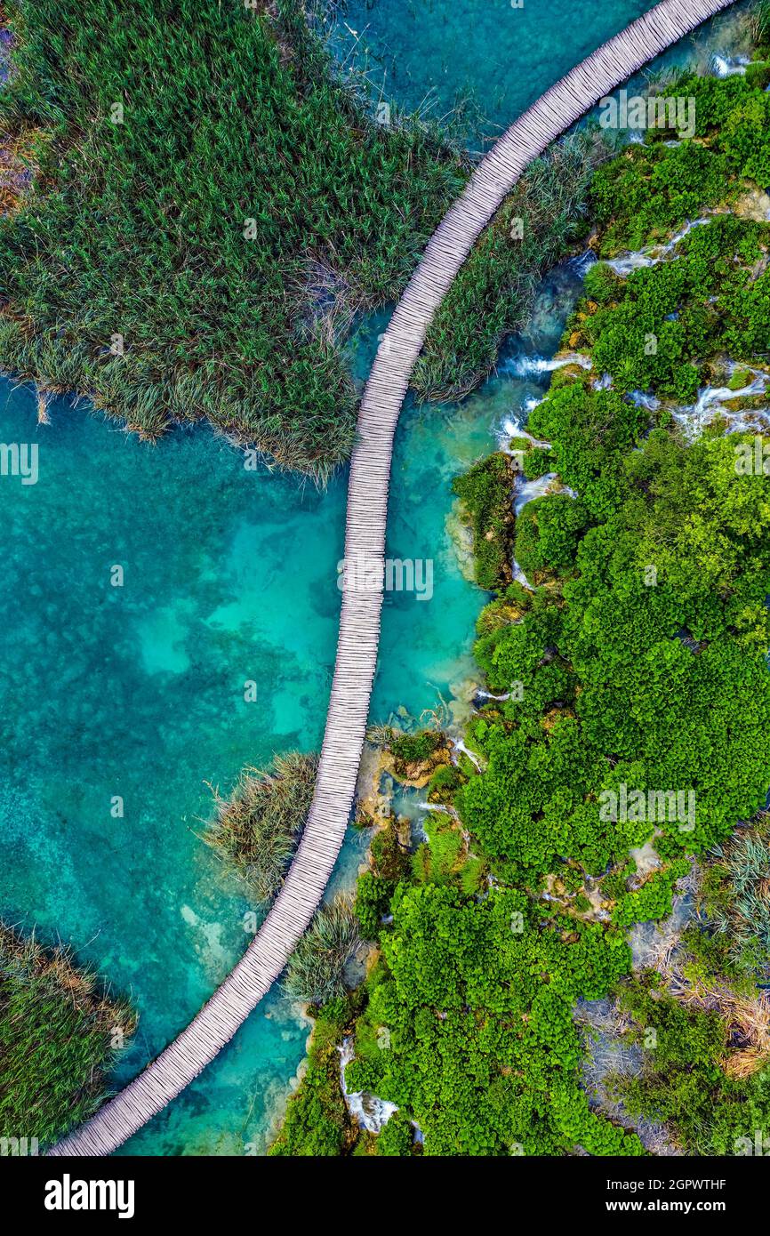 Plitvice, Croazia - veduta aerea dall'alto in basso di una passerella in legno nel Parco Nazionale dei Laghi di Plitvice in una luminosa giornata estiva con acque turchesi e acqua Foto Stock
