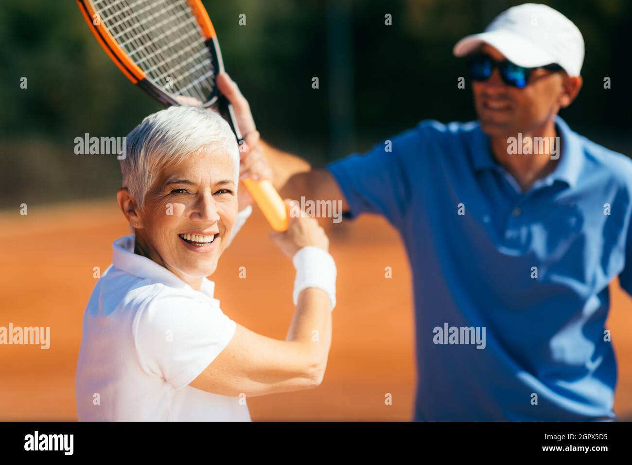 Istruttore di tennis insegnare Donna anziana come giocare a tennis Foto  stock - Alamy