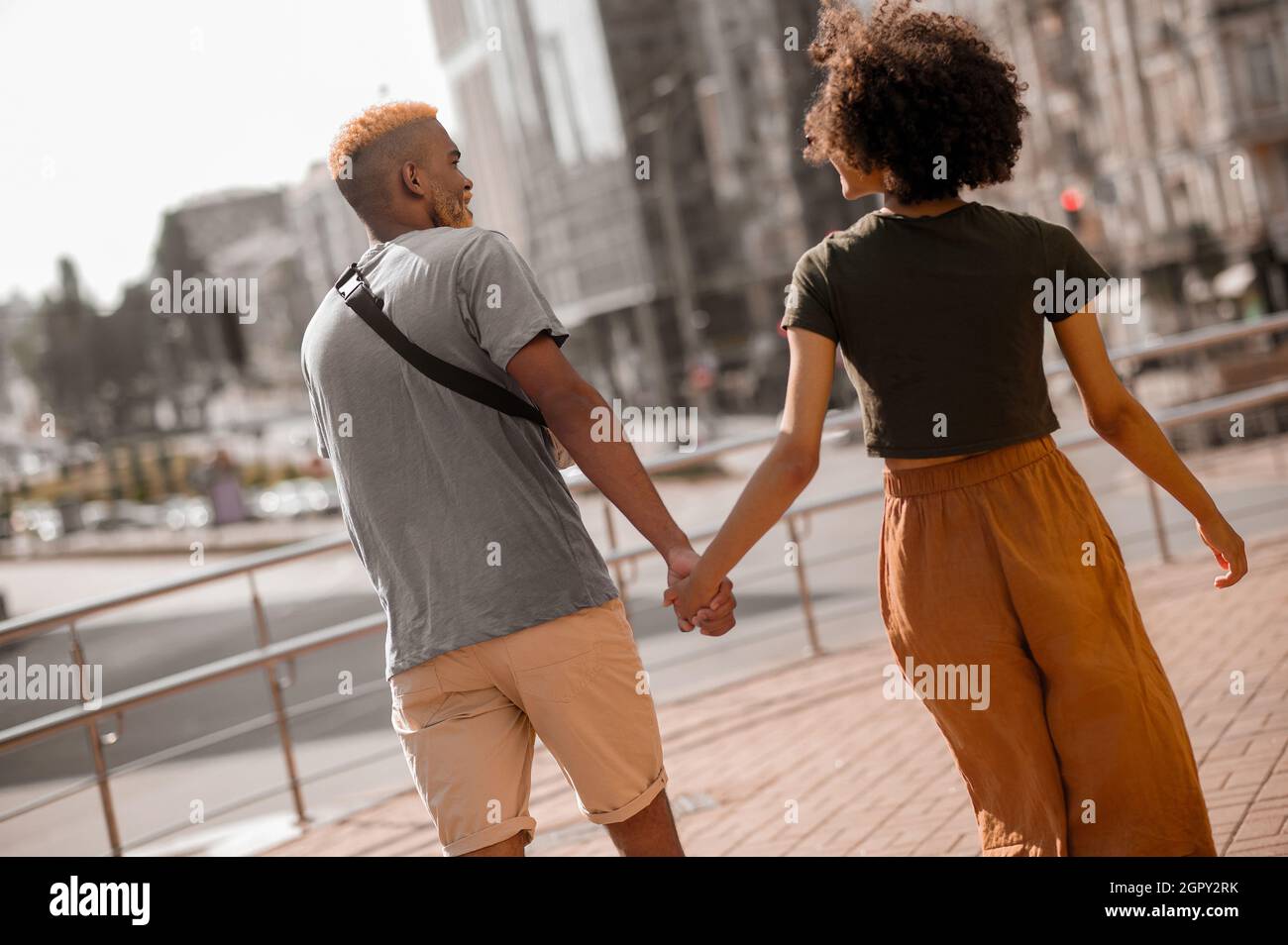 Una felice coppia di pelle scura in strada che guarda eccitato Foto Stock