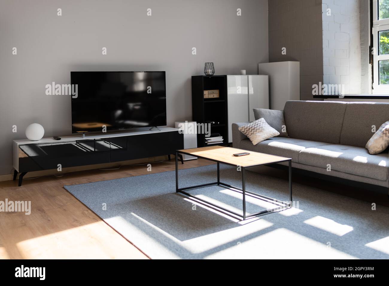 Mobili TV interni in soggiorno con pavimento in legno Foto Stock