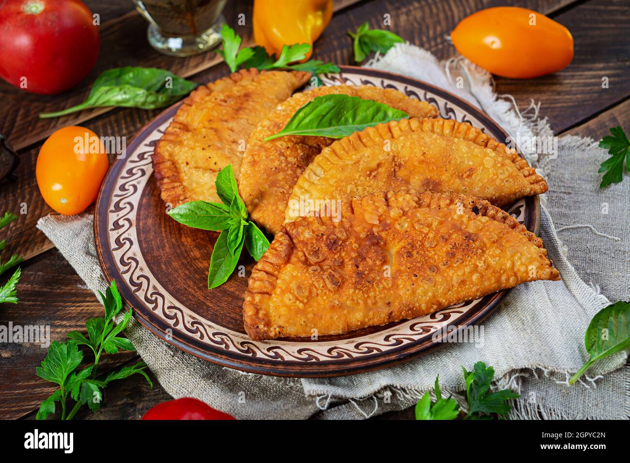 Cucina tradizionale Tatar Crimea, chebureki con carne di pollo. Empanadas fritto su sfondo di legno Foto Stock
