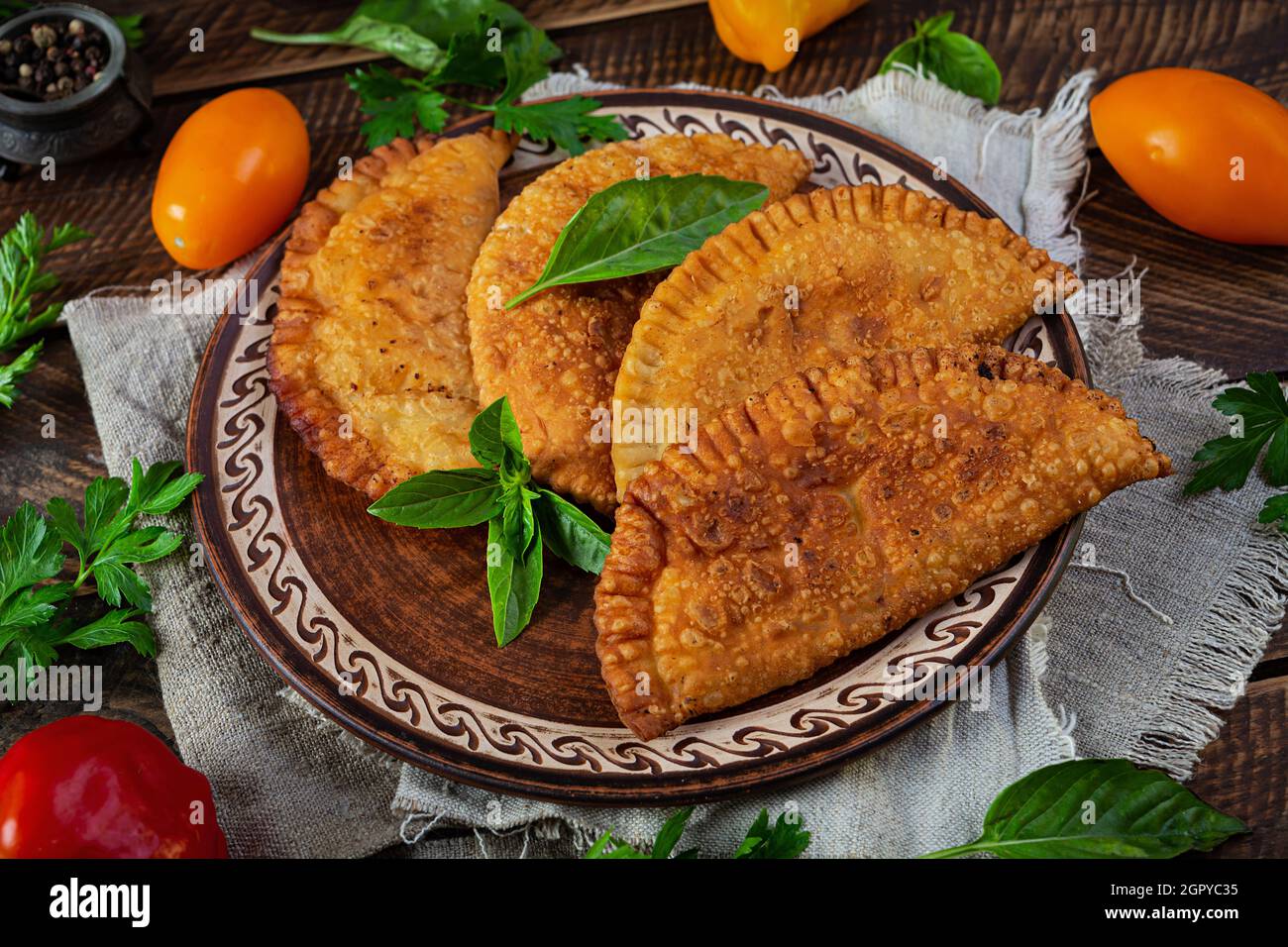 Cucina tradizionale Tatar Crimea, chebureki con carne di pollo. Empanadas fritto su sfondo di legno Foto Stock