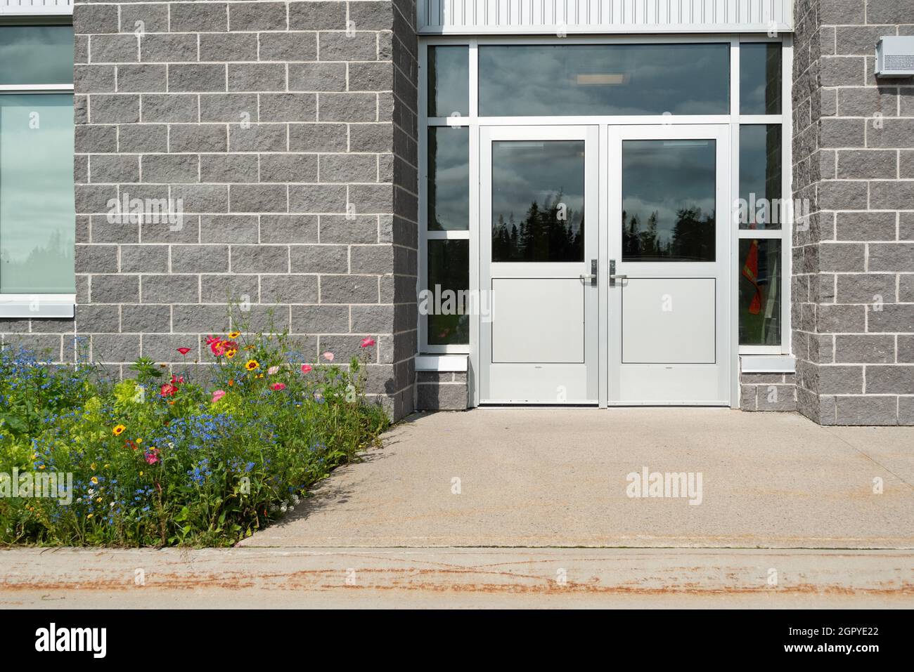 Doppie porte commerciali esterne di un business. Il vetro è sulla parte superiore, il rivestimento è in acciaio inossidabile. Le porte sono dotate di maniglie metalliche. Sono presenti grandi grigi Foto Stock