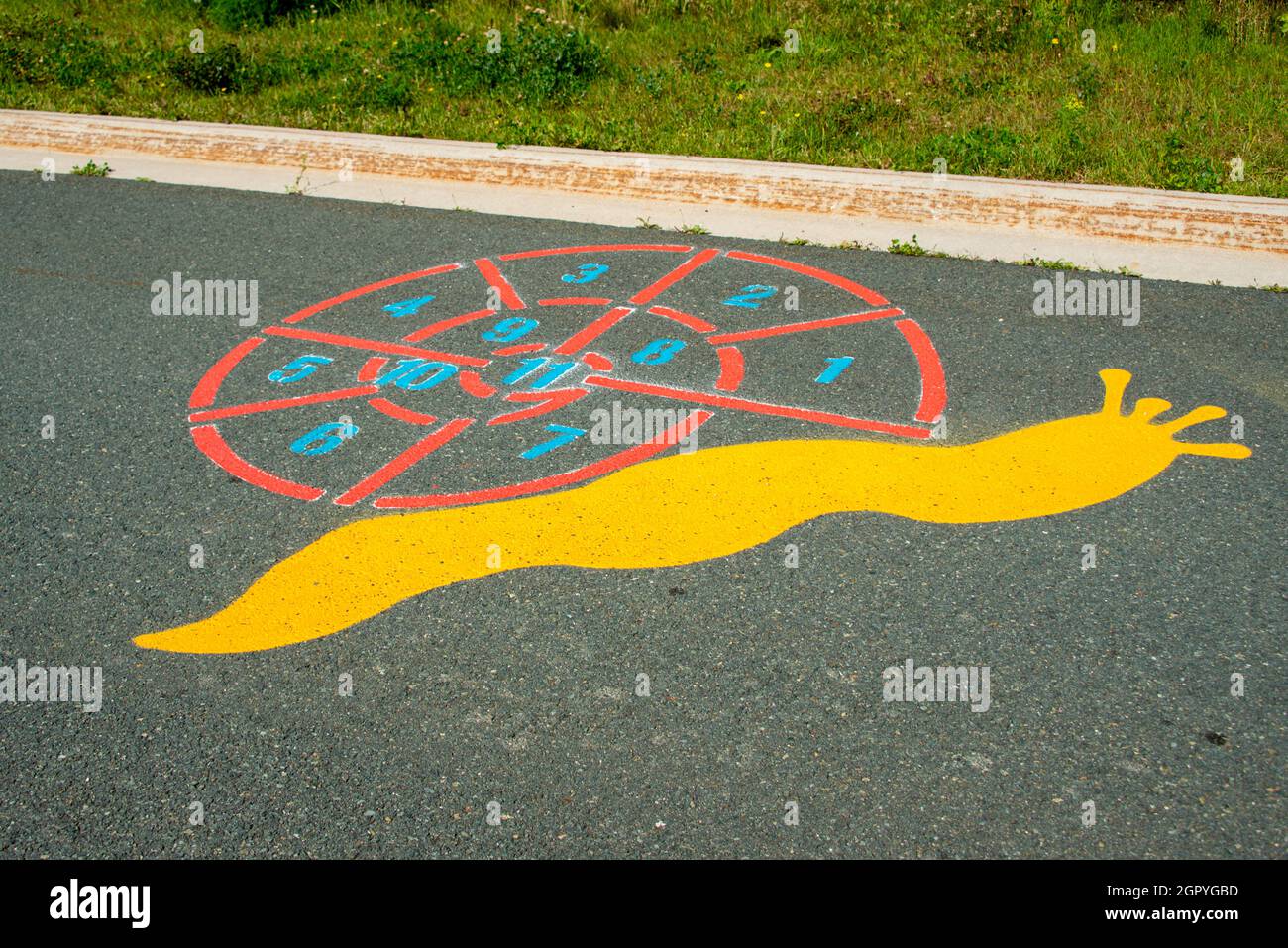 Un colorato gioco di divertimento per bambini all'aperto a forma di lumaca. Ci sono numeri o gioco di conteggio sulla parte shell della figura dipinta. Foto Stock