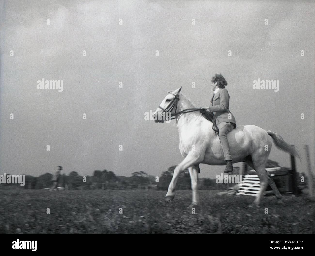 Anni '50, storico, fuori in un campo, una signora rider sul suo cavallo che partecipa a una competizione di eventi, Sussex, Inghilterra, Regno Unito. Foto Stock