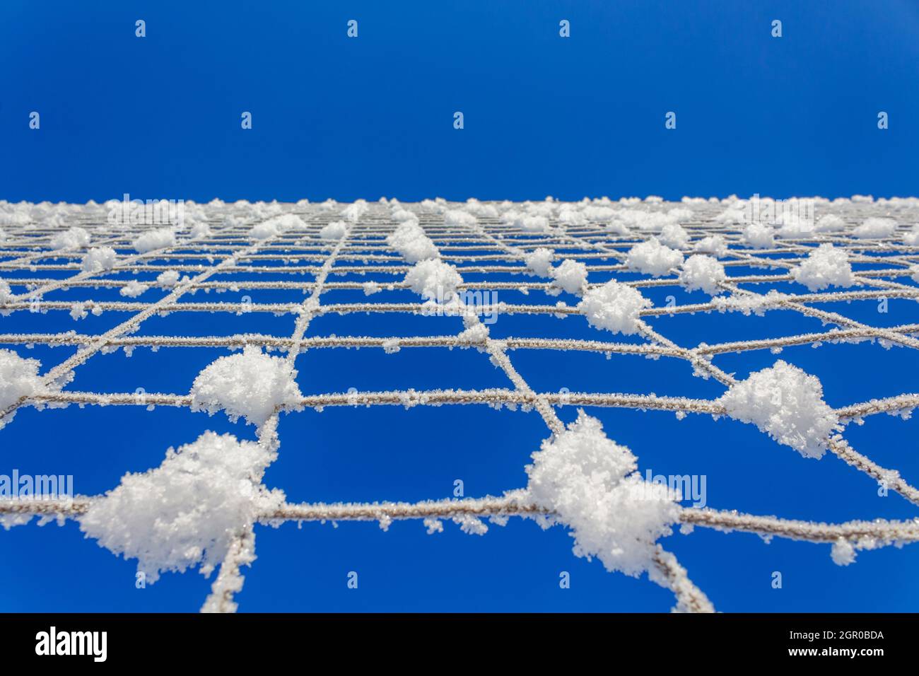 Rete da pallavolo coperta di neve. Minimalismo della natura. Foto Stock