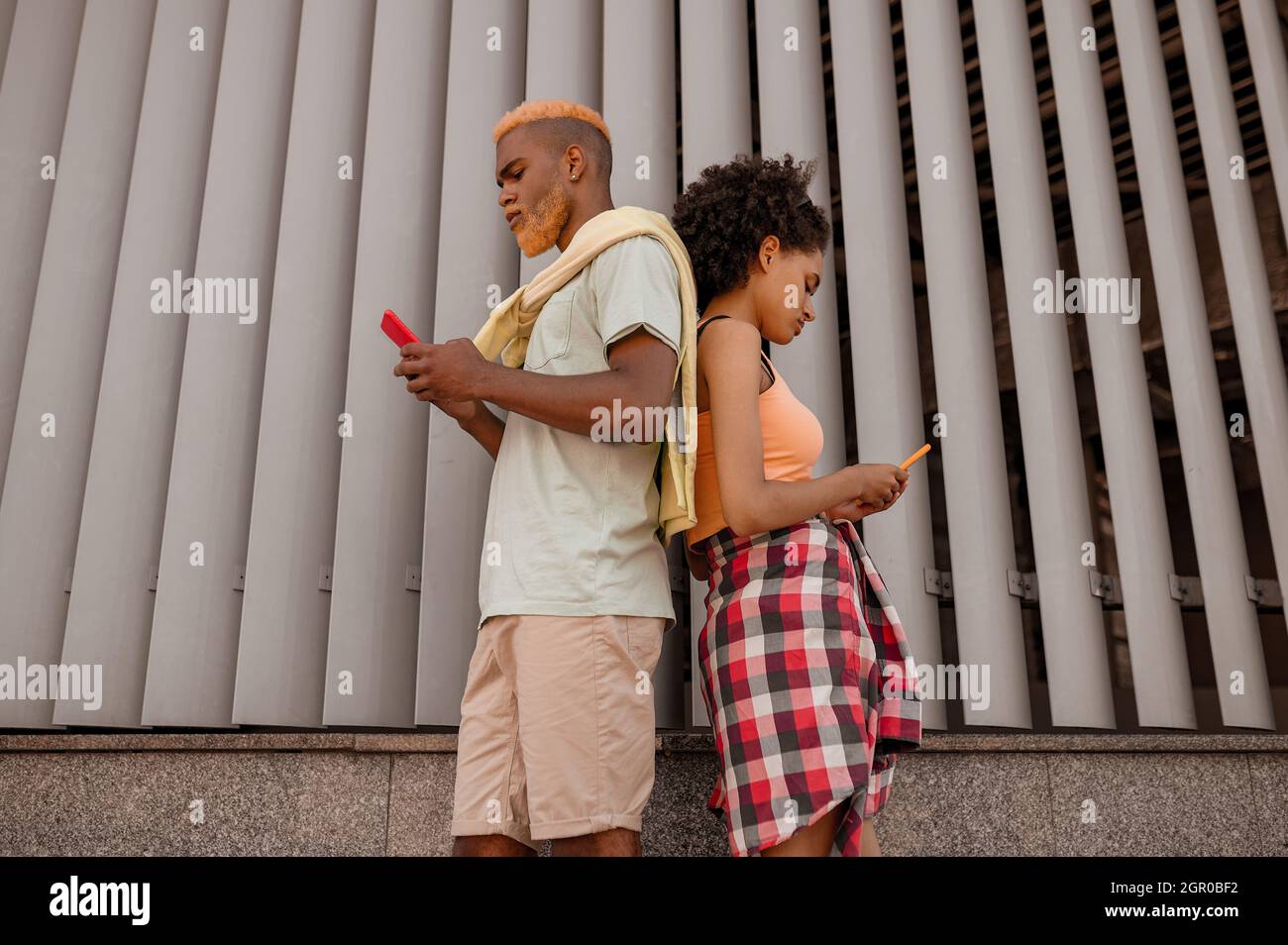 Una giovane coppia con smartphone in mano che guarda coinvolti Foto Stock