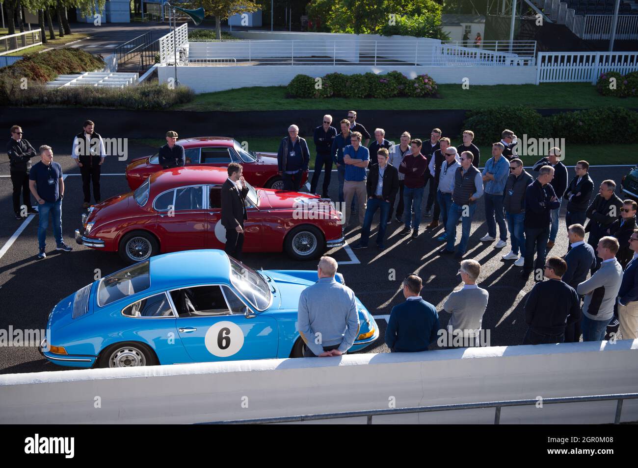 I conducenti in griglia vengono istruiti prima di guidare le auto classiche a Goodwood. Foto Stock