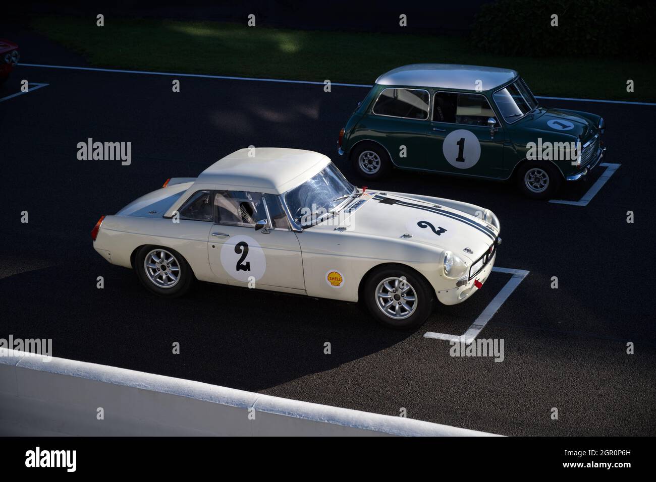 Un classico MGB bianco si è schierato sulla griglia di Goodwood con un Mimi rosso nella successiva posizione della griglia. Foto Stock