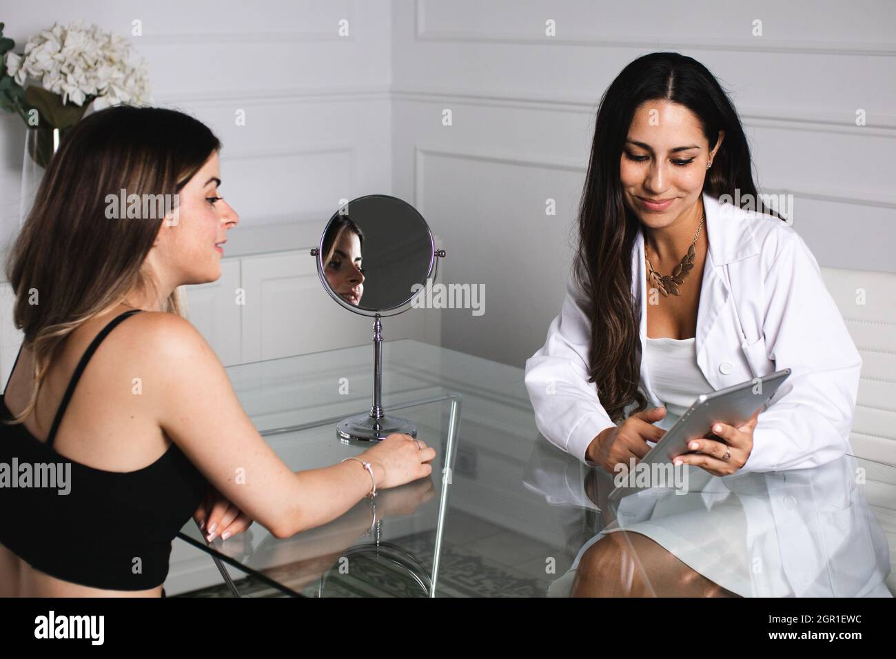 Una giovane dottore che consulti una giovane donna Foto Stock
