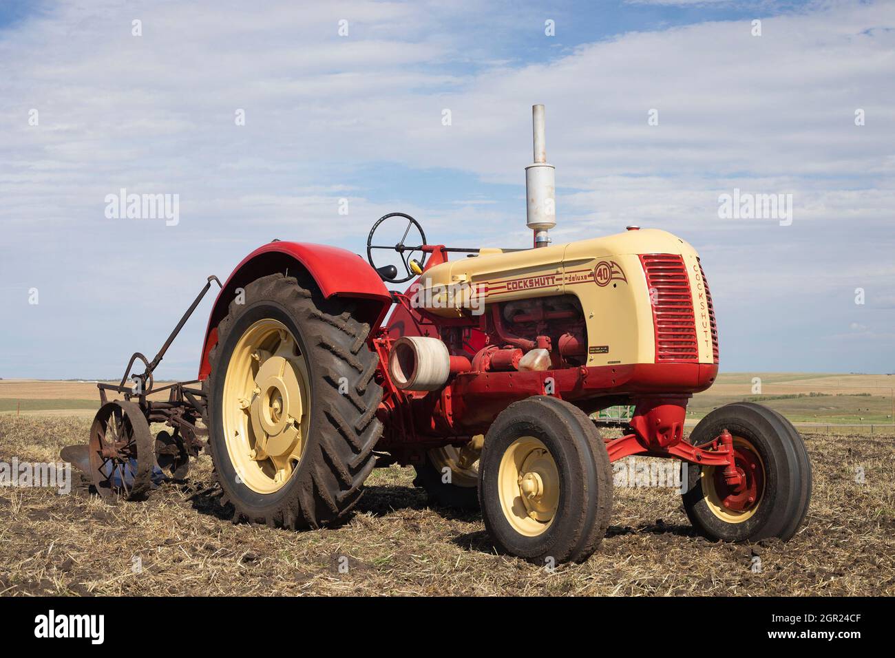 Trattore d'epoca Cockshutt modello 40 Deluxe che tira l'aratro in un campo agricolo fino al suolo dopo la raccolta in autunno. Questo modello è stato prodotto tra il 1949 e il 1958 Foto Stock