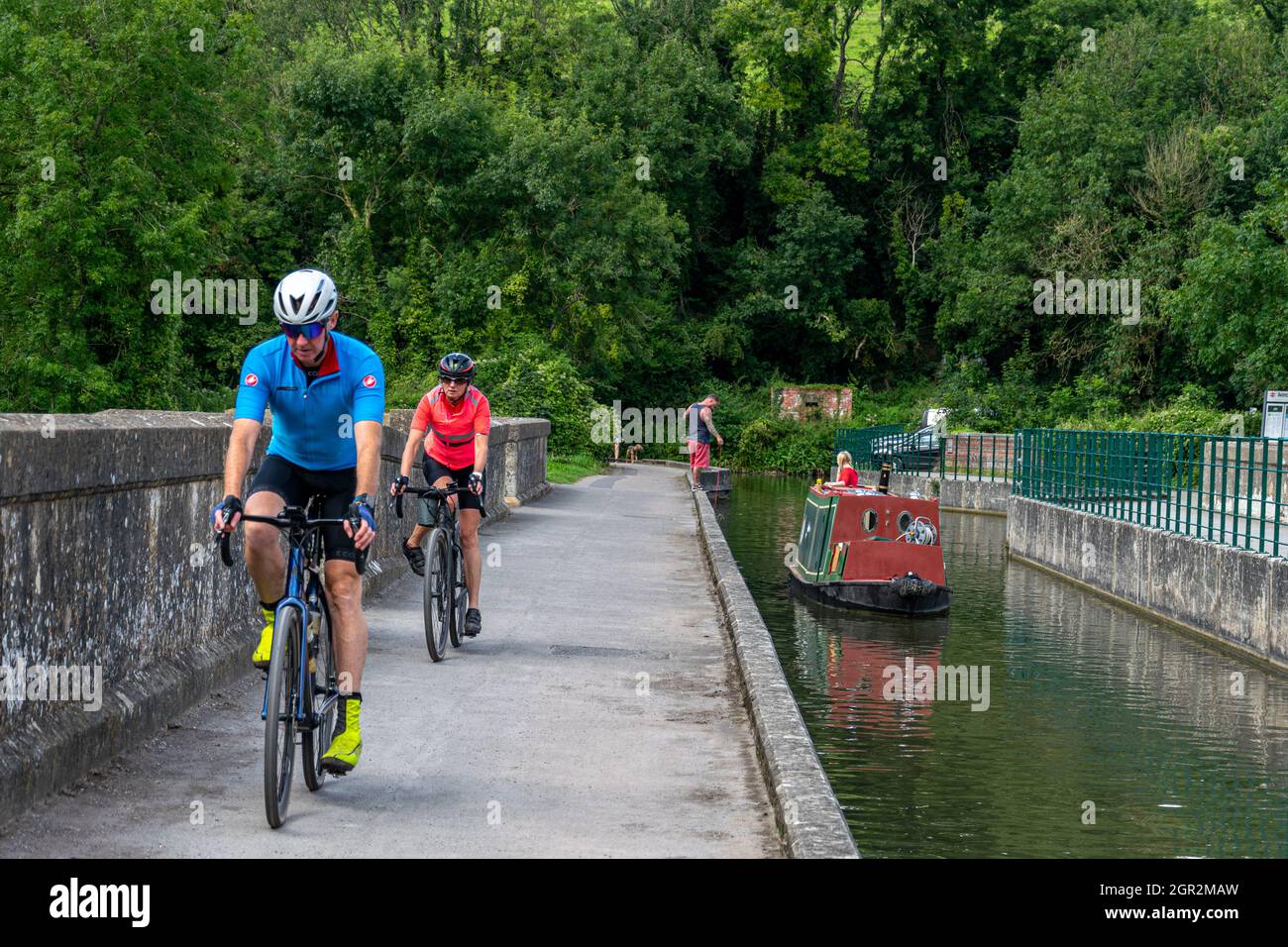 Ciclisti che attraversano l'acquedotto di Avoncliff, Wiltshire, Inghilterra Foto Stock