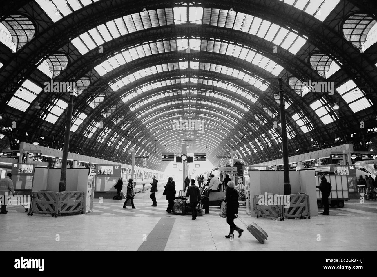 02-22-2014 Milano. Treno italiano e piattaforma ferroviaria della stazione ferroviaria di Milano e giovane donna walking.stilizzazione di bianco e nero Foto Stock