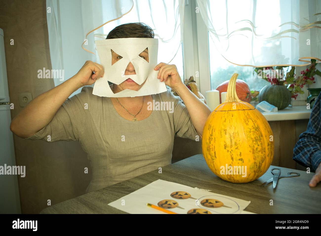 Facendo Jack o'Lantern a casa. La zucca è pronta per affettare. La donna è felice con il loro lavoro e ridere e scherzare. Foto Stock