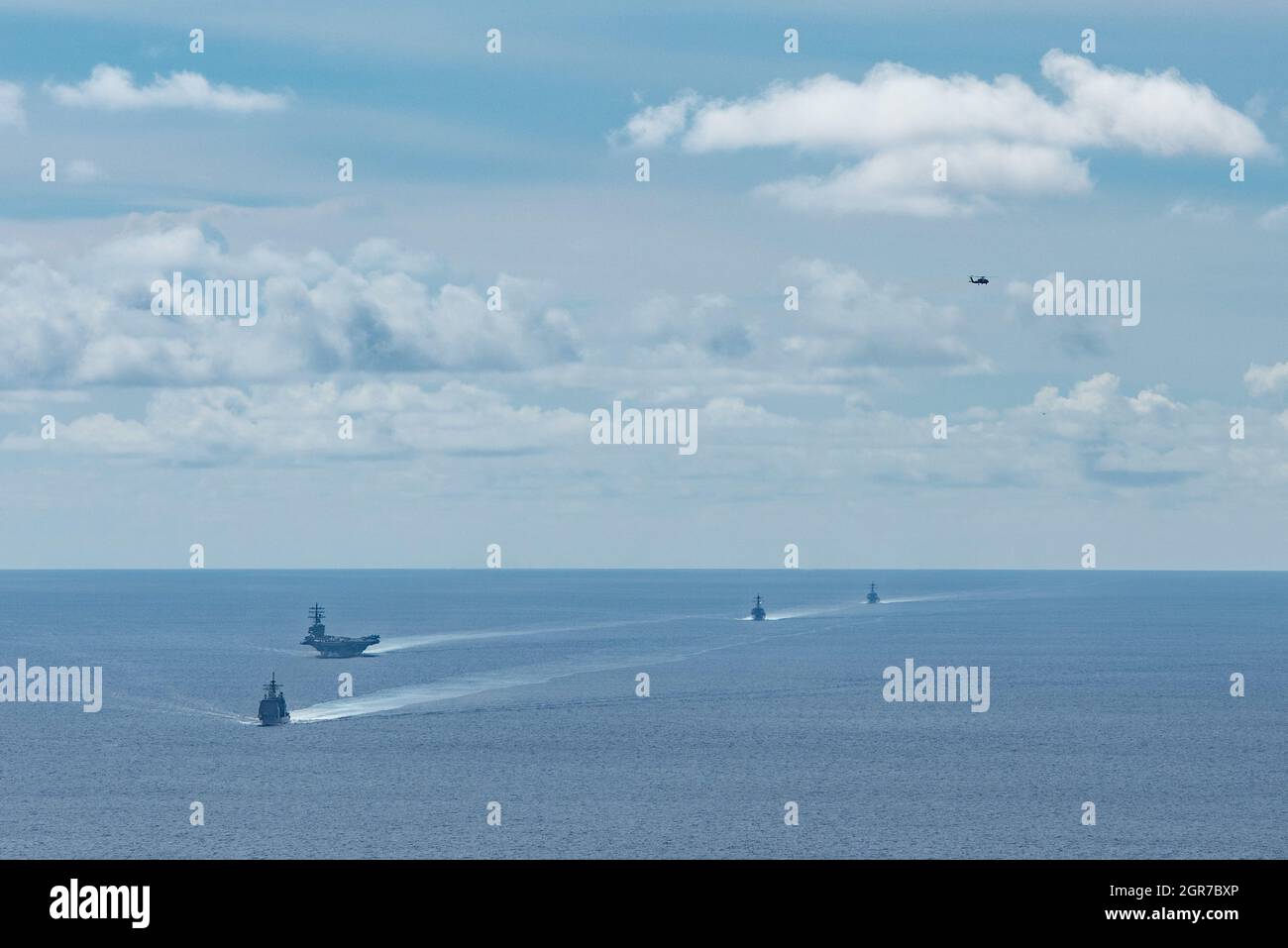 210927-N-RF825-1074 SAN BERNARDINO STRETTO (DAL 27, 2021) da sinistra, l'incrociatore missilistico guidato classe Ticonderoga USS Shiloh (CG 67), l'unica compagnia aerea della Marina statunitense USS Ronald Reagan (CVN 76), il cacciatorpediniere missilistico guidato classe Arleigh Burke USS Chafee (DDG 90), E il cacciatorpediniere missilistico guidato di classe Burke di Arleigh USS Stockdale (DDG 106) conduce un passaggio arcipelagico via mare attraverso lo stretto di San Bernardino, attraversando il Mar Cinese Meridionale nel Mare delle Filippine mentre un falco marino MH-60R, attaccato ai “Saberhawks” dello Sciopero marittimo di Helicopter Squadron (HSM) 77, vola ab Foto Stock