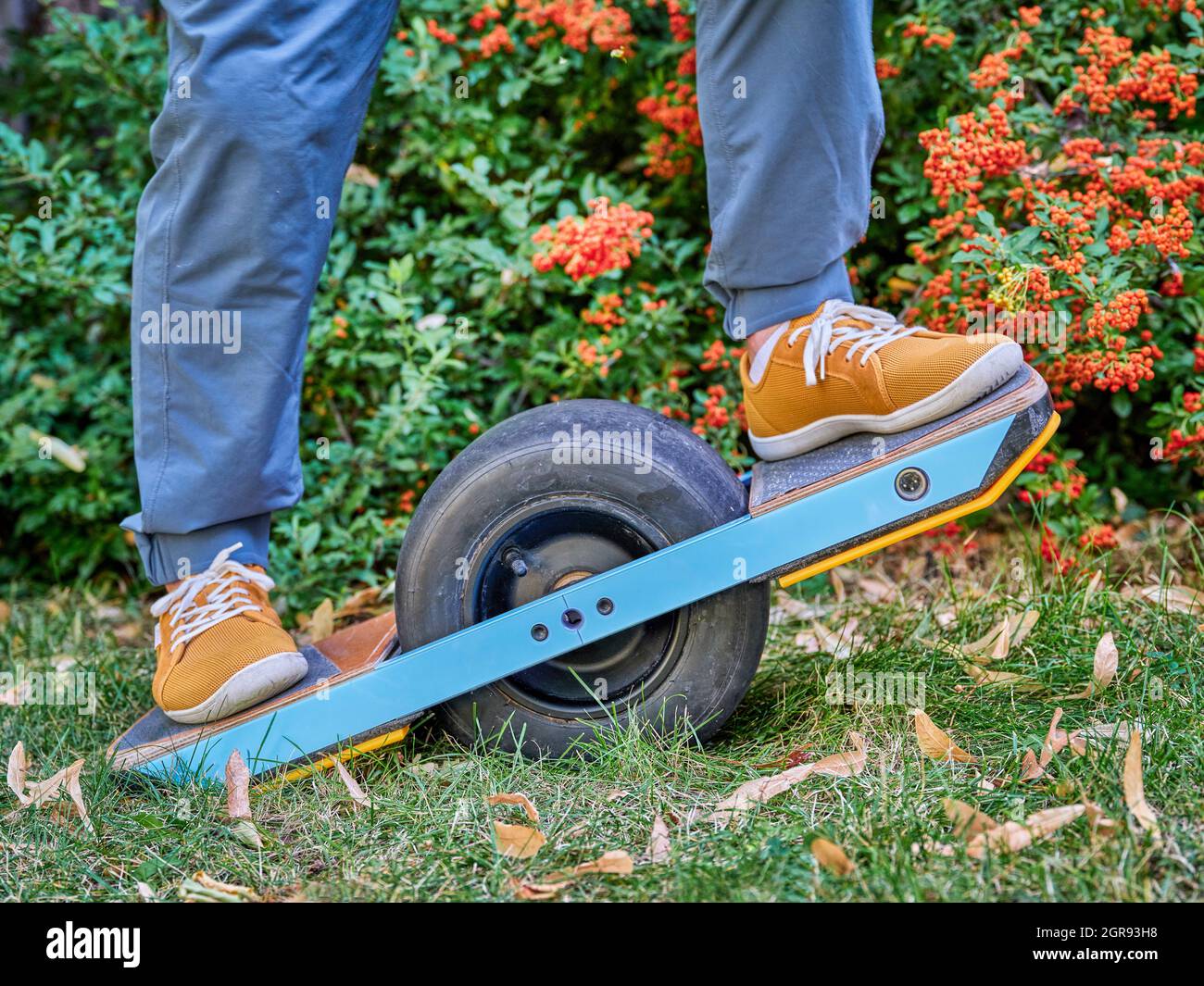 cavalcare uno skateboard elettrico a una ruota in un cortile o un parco Foto Stock