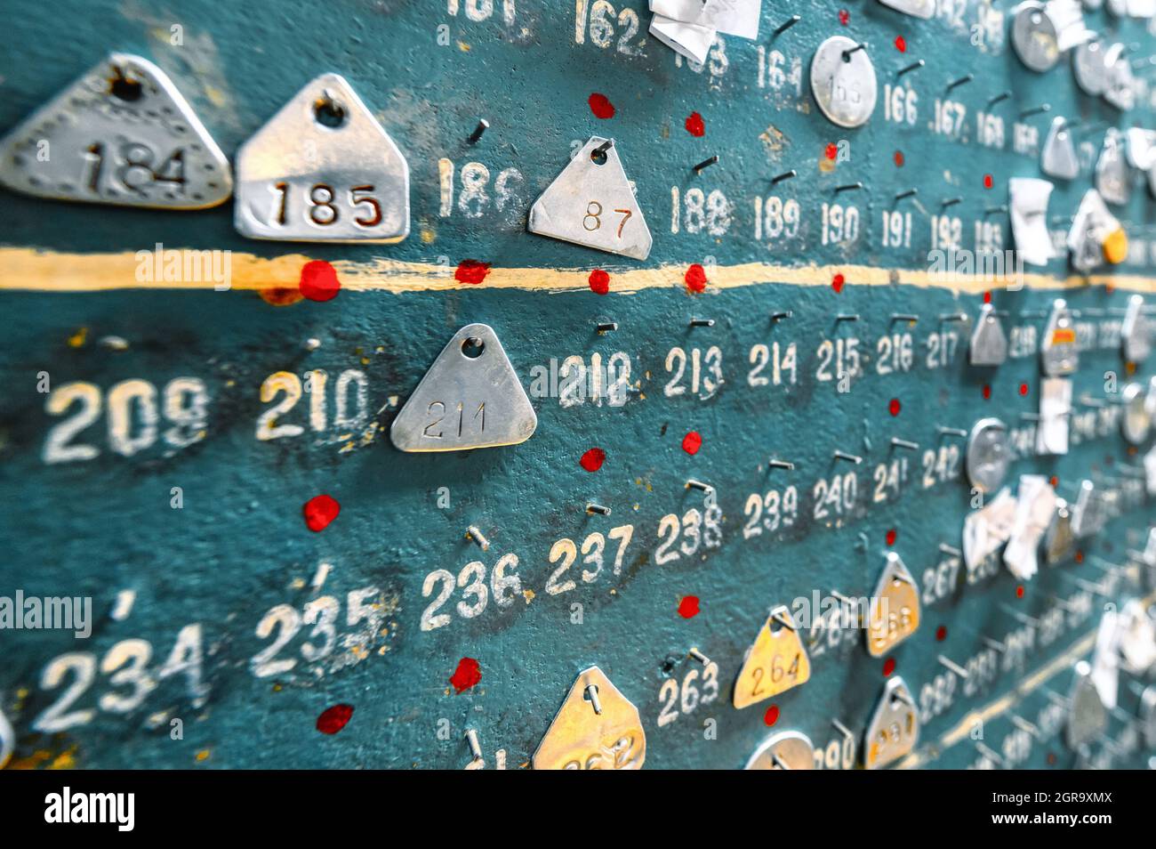Etichette identificative minatori in alluminio appese a un pannello di legno Foto Stock