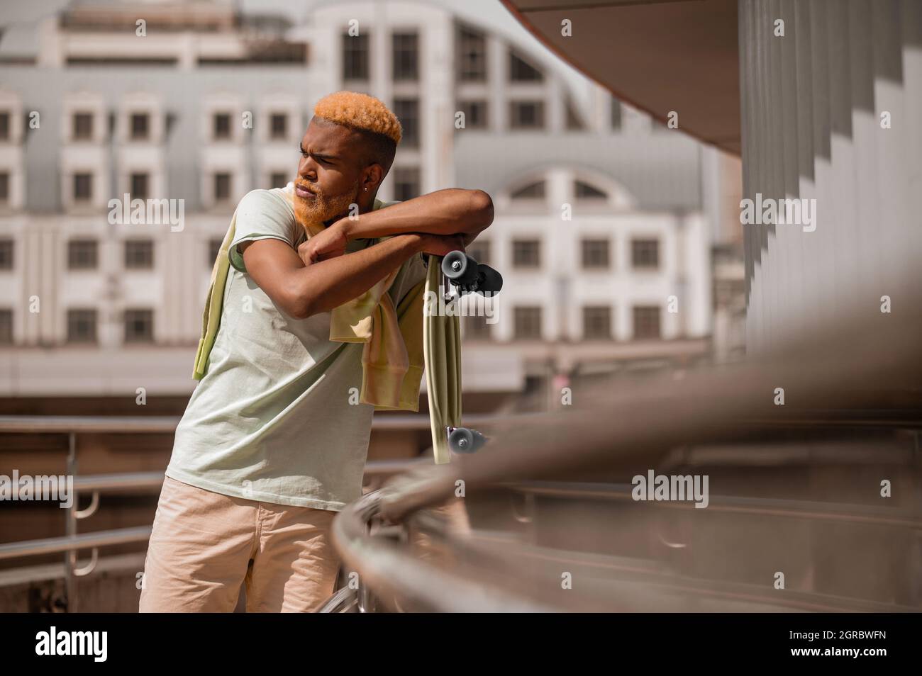 Giovane uomo con pelle scura con skateboard Foto Stock