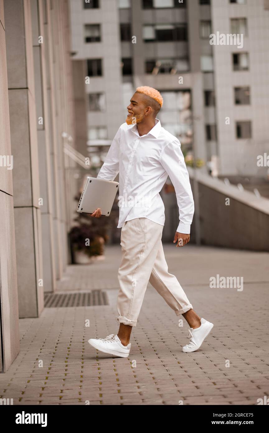 Uomo in abiti bianchi con un gadget in mano Foto stock - Alamy