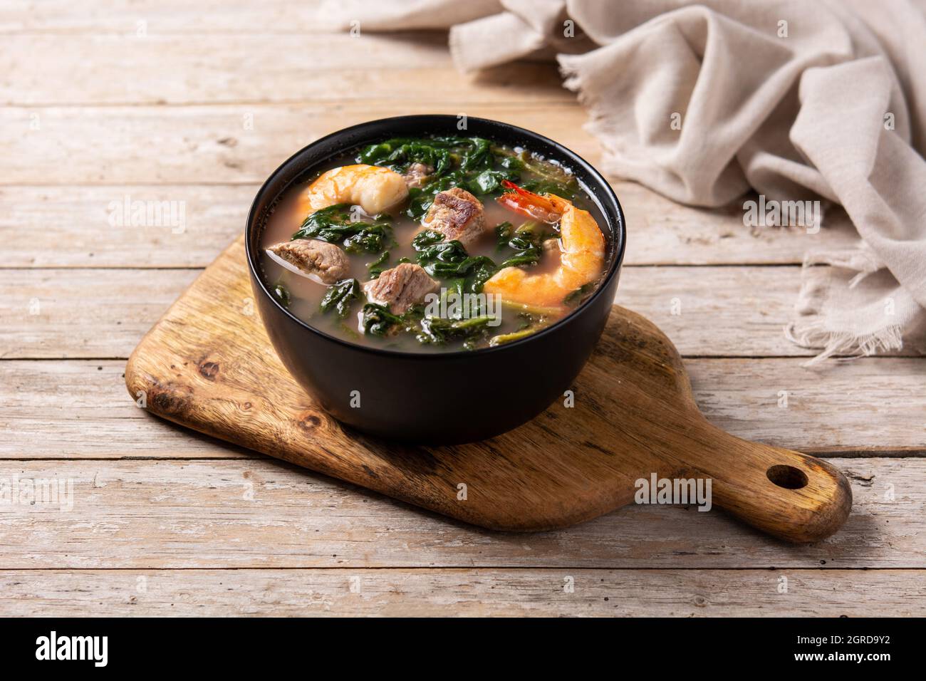 Zuppa di manzo, stufato di okra e spinaci in ciotola su tavola di legno Foto Stock