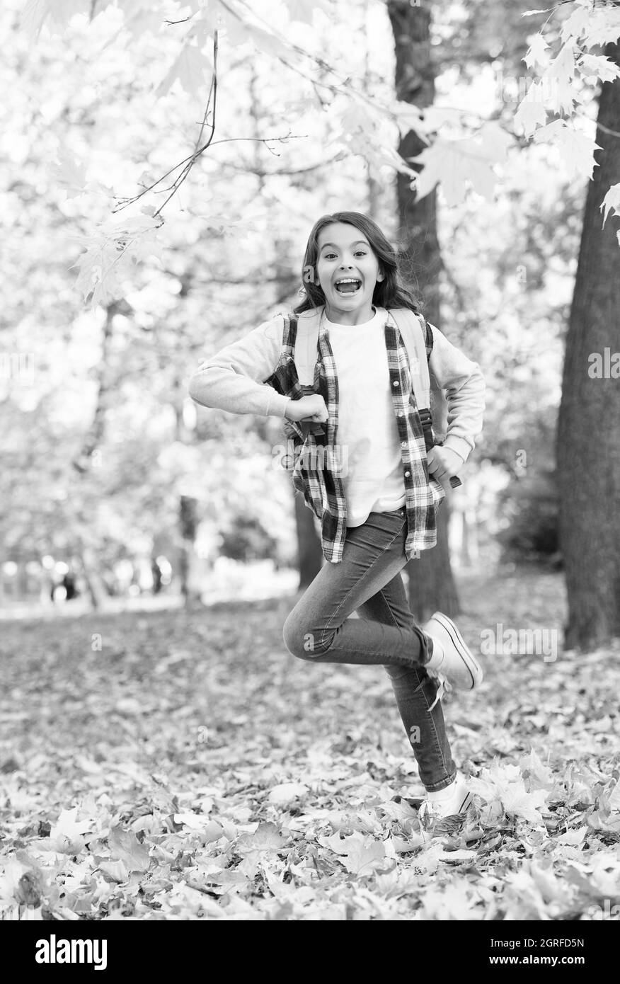 Energico piccolo bambino portare zaino correre a scuola in autunno parco all'aperto, 1 settembre Foto Stock